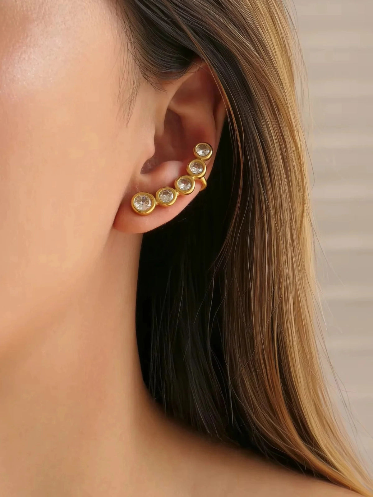 Ana Earring & Cuff – On Ear gold-Close-up of a person wearing gold earrings with clear stones.