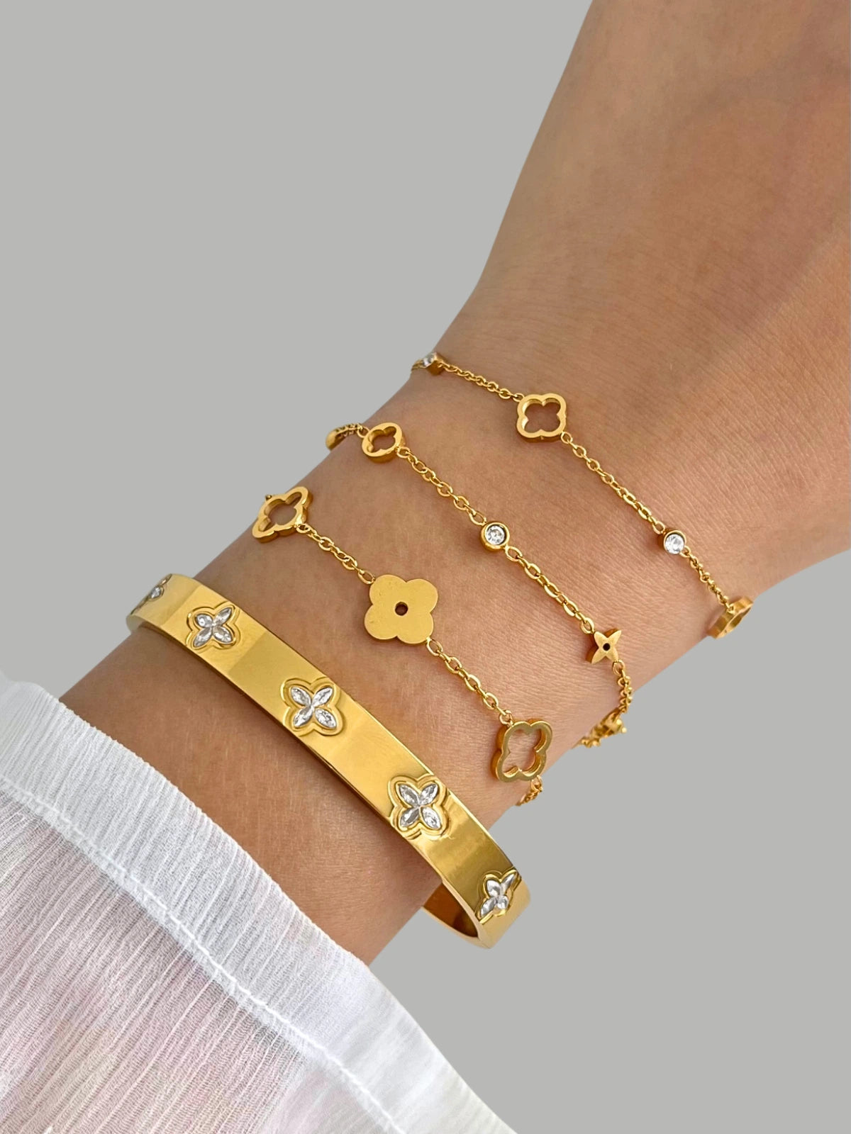 Blaise Bracelet Gold bracelets on a wrist with a gray background