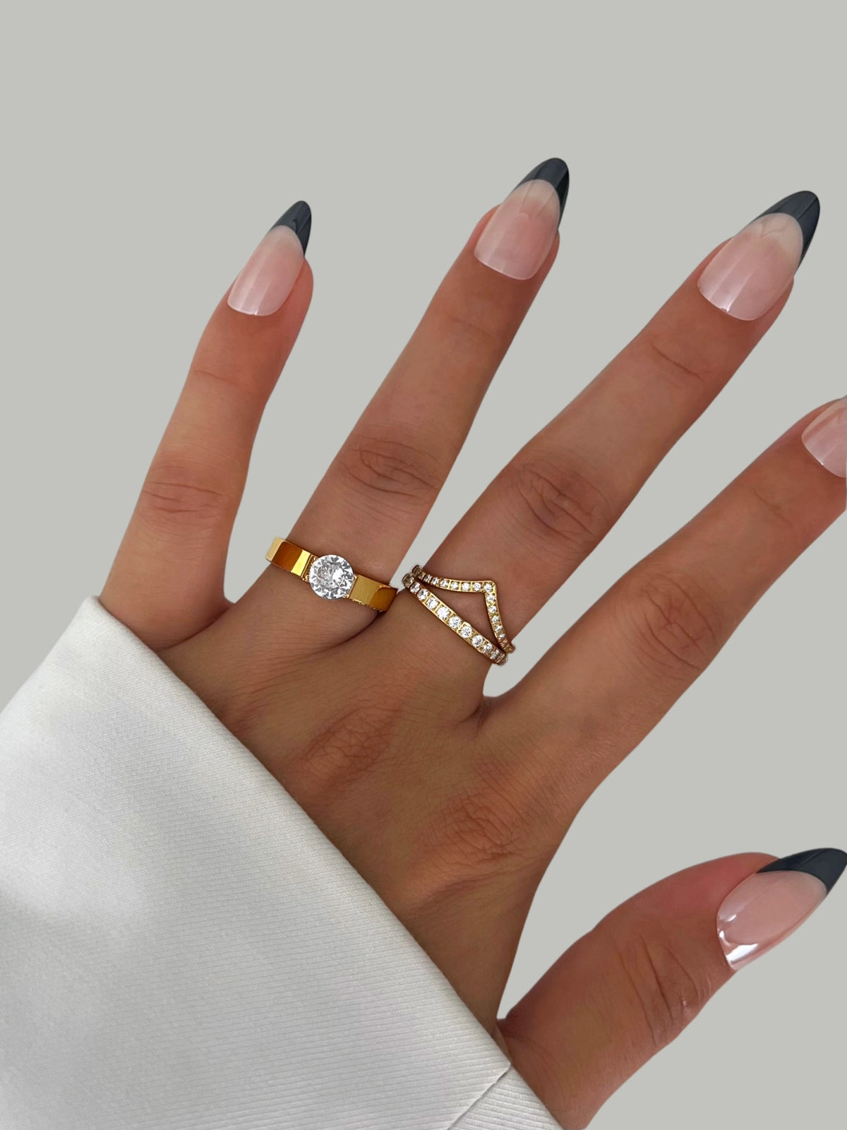 Camille Ring Hand wearing two rings with a plain background