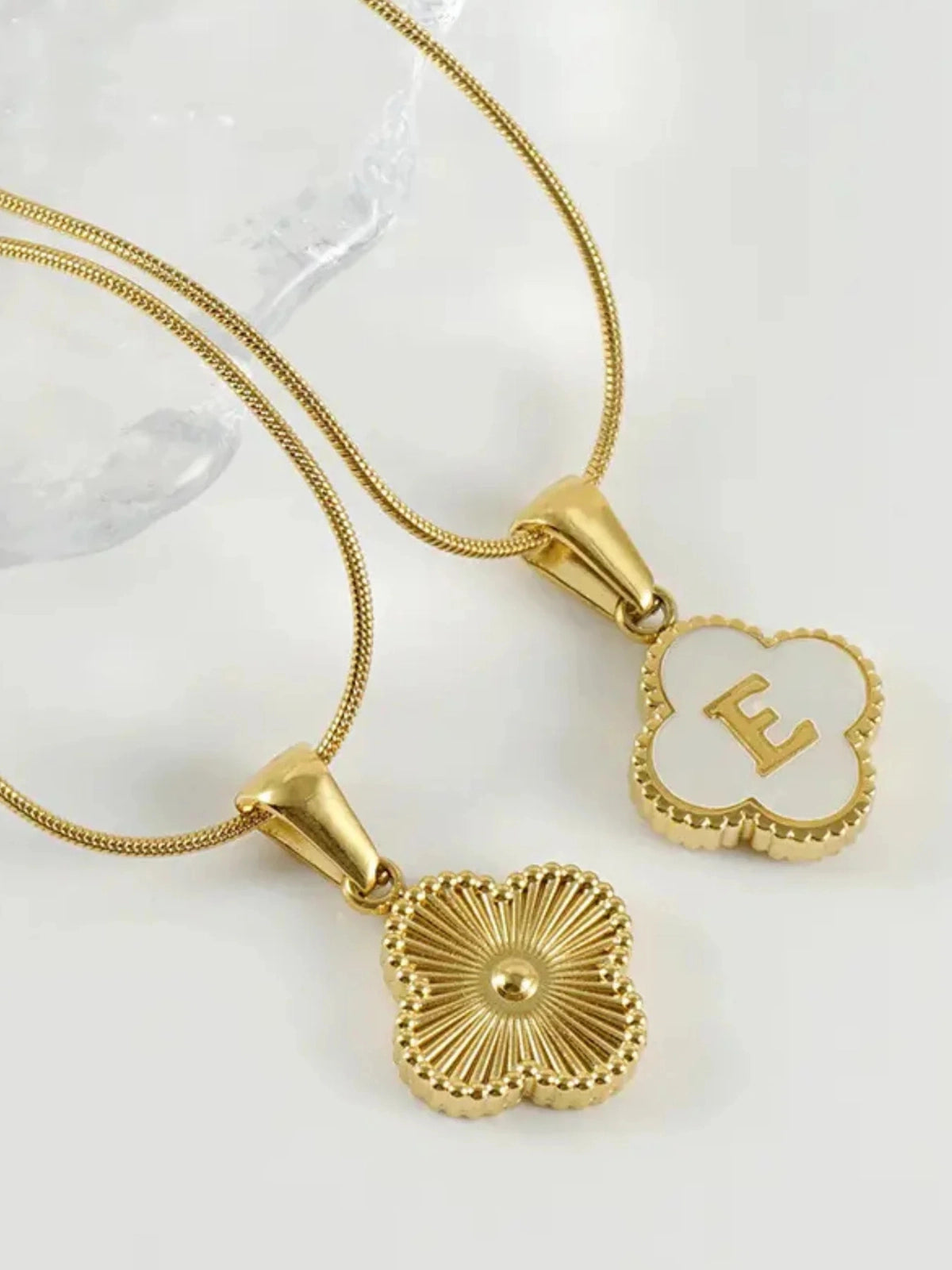 Clover Letter Necklace – Close‑Up Detail-Two gold necklaces with pendants on a white background