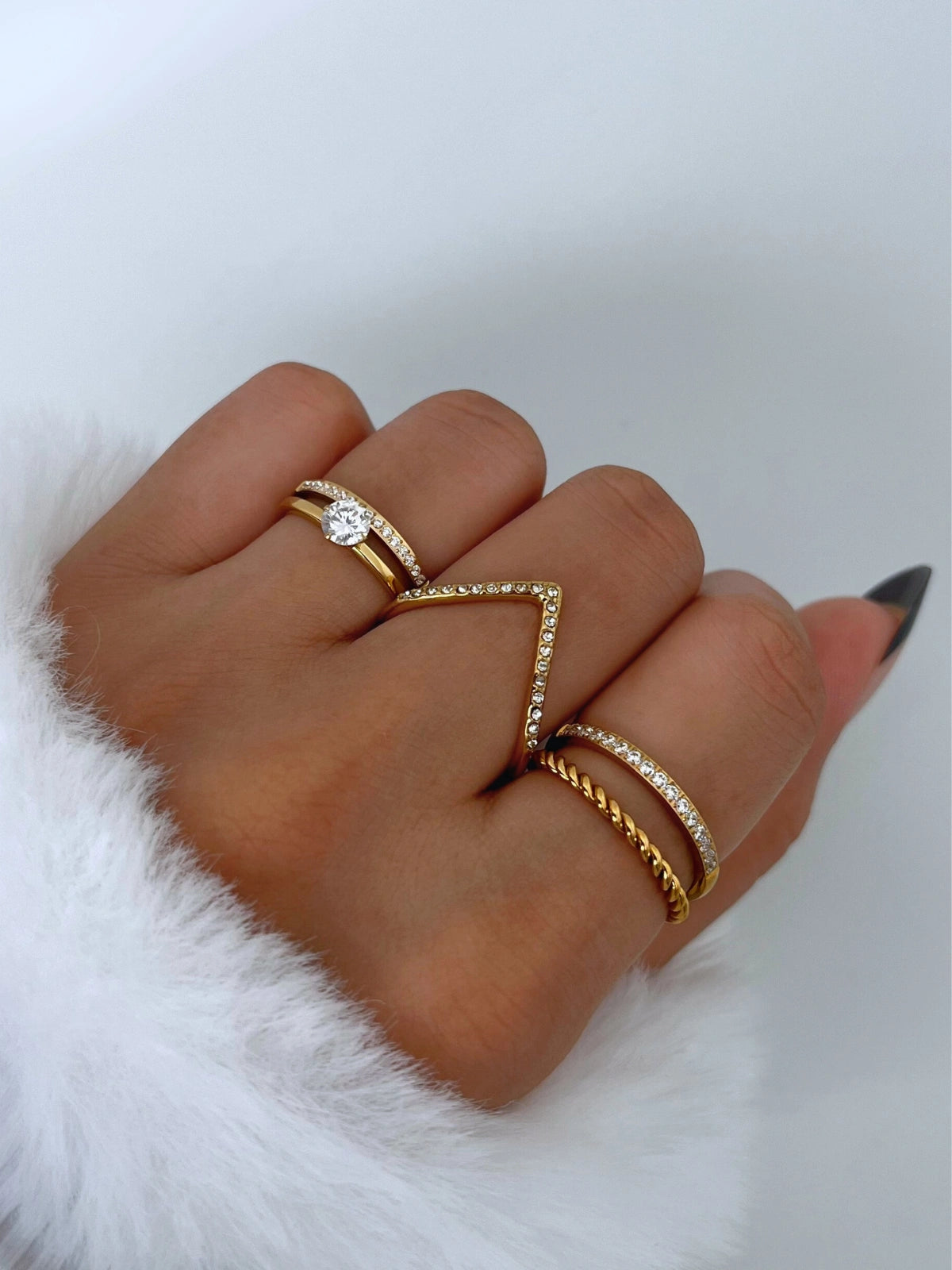 Crush Vow Ring – On Model Styled Shot-Hand wearing multiple gold rings on a white background