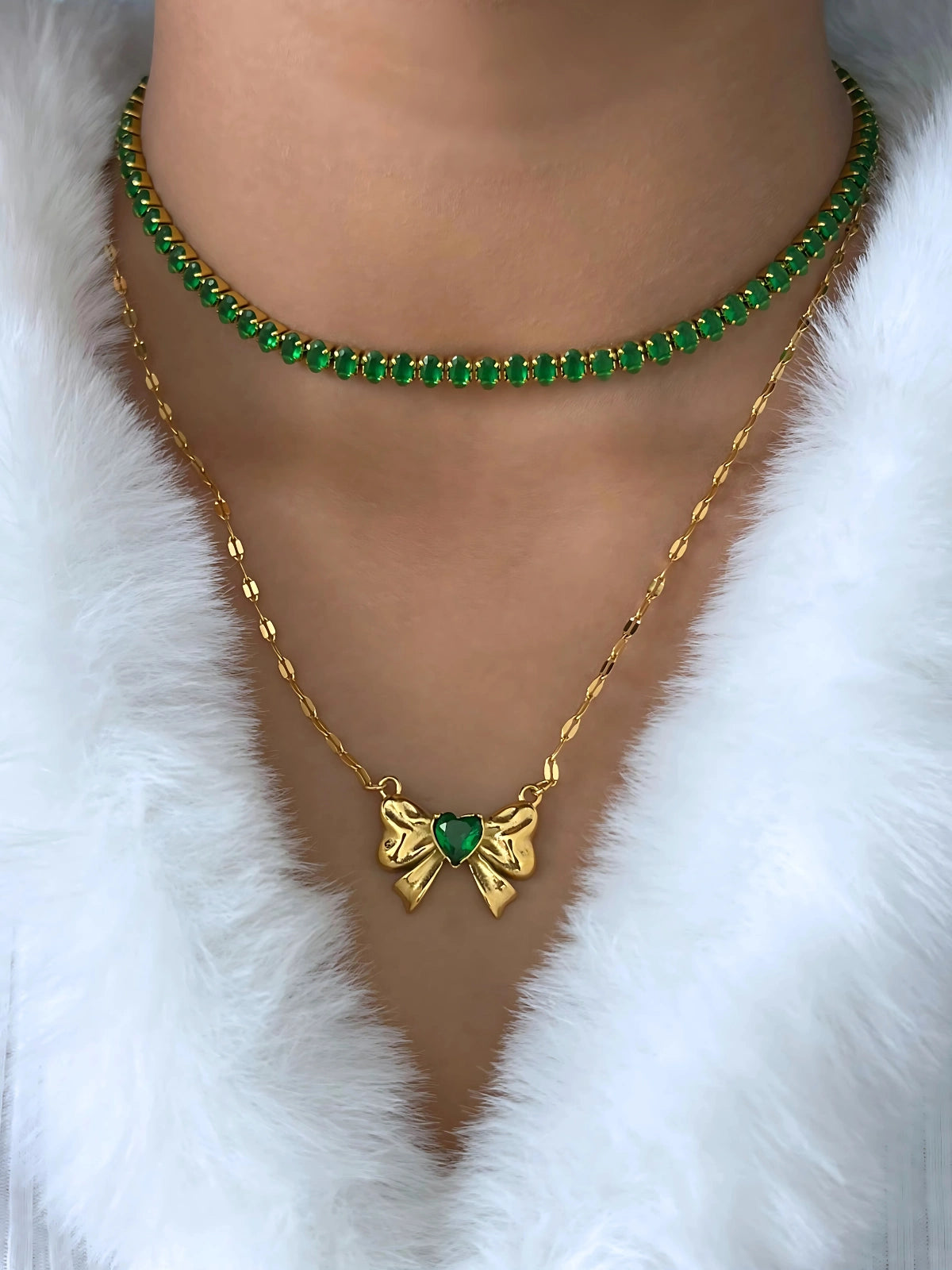 Daisy Chain Bracelet – Close-Up Detail-Necklace-Gold necklace with green gemstones on a white fur background