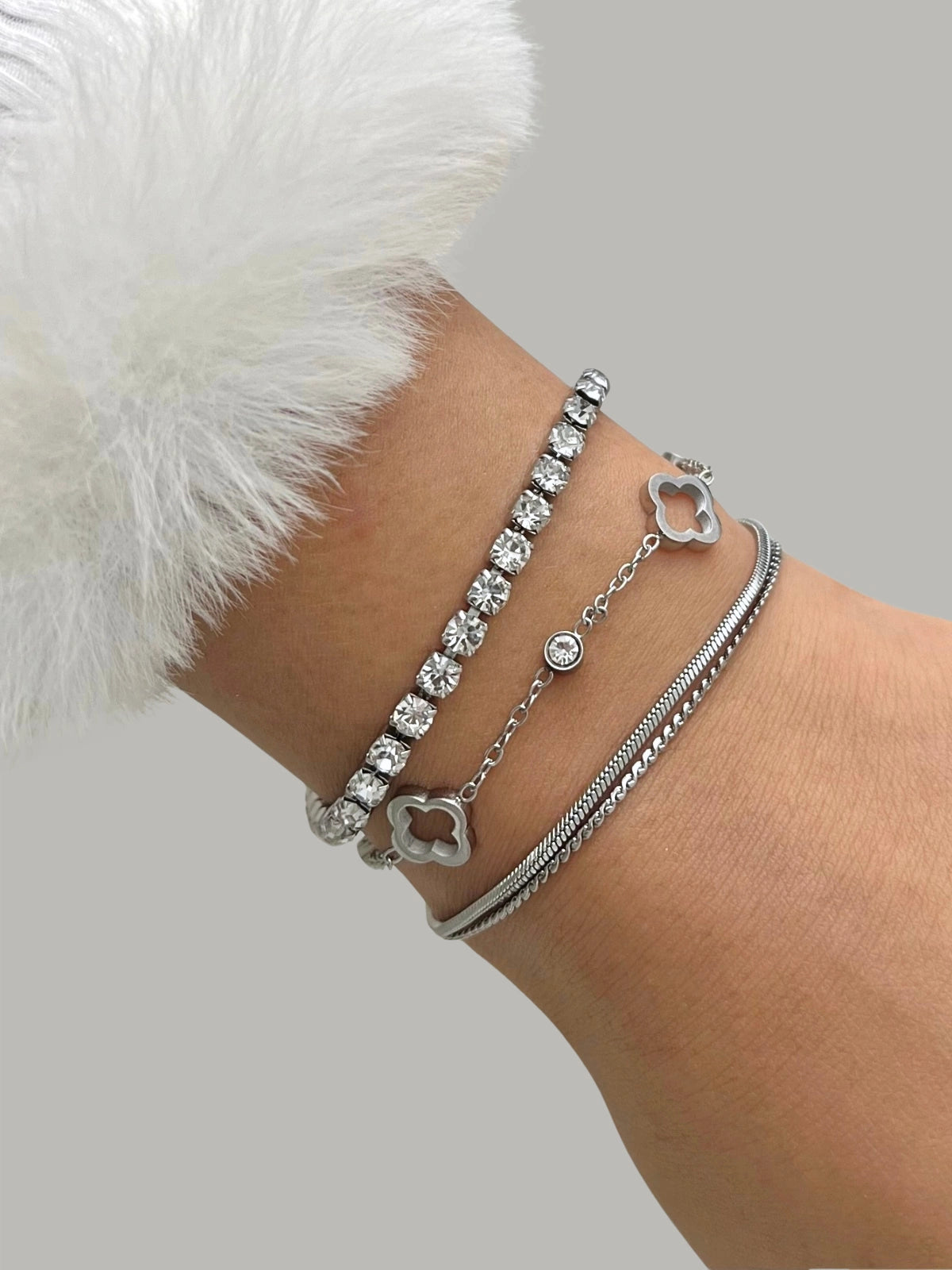 Elle Clover Bracelet – On Wrist. Silver bracelet with heart charm on wrist against a neutral background