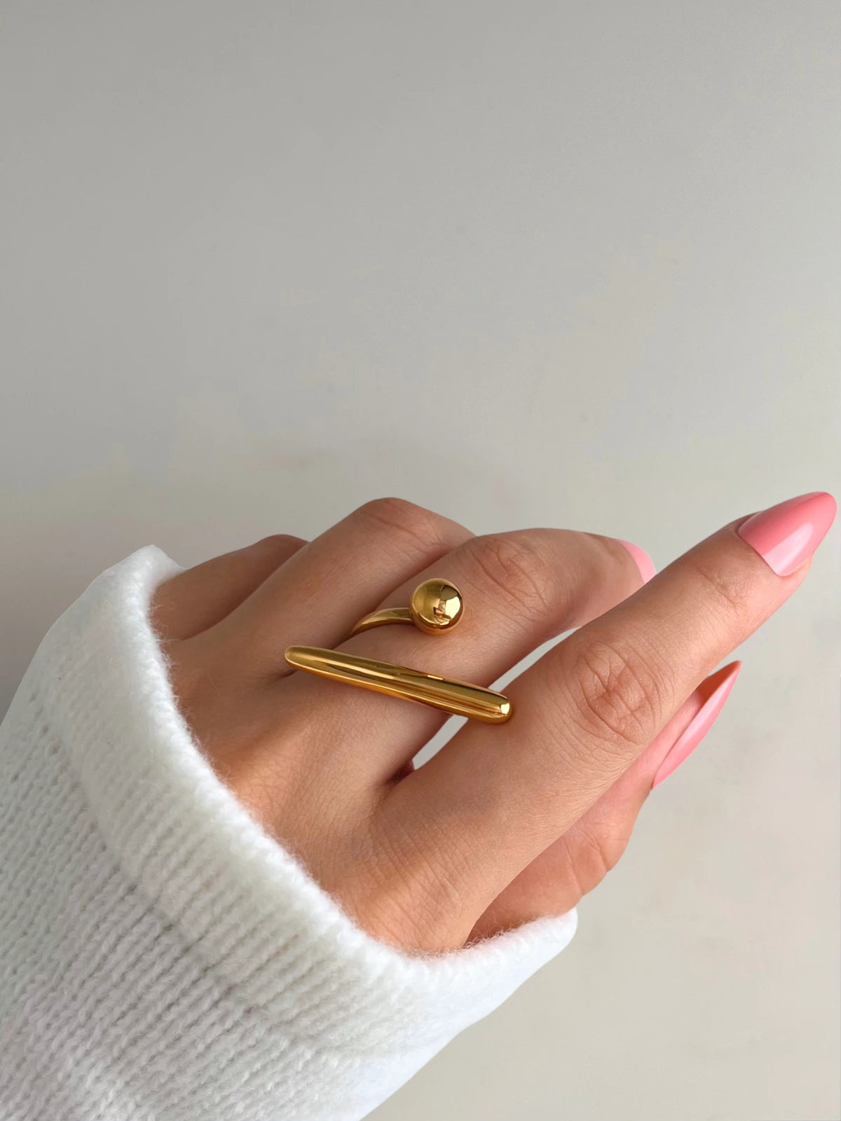 Ellowen Ring Gold ring on a finger with a plain background