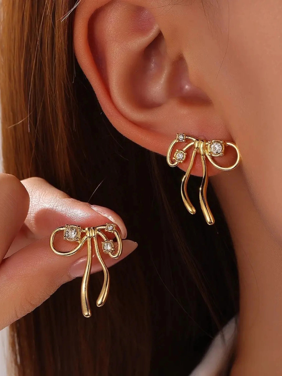 Elora Bow Earring worn on ear — 18K gold-plated stainless steel bow-design by Shine With Me styled look.