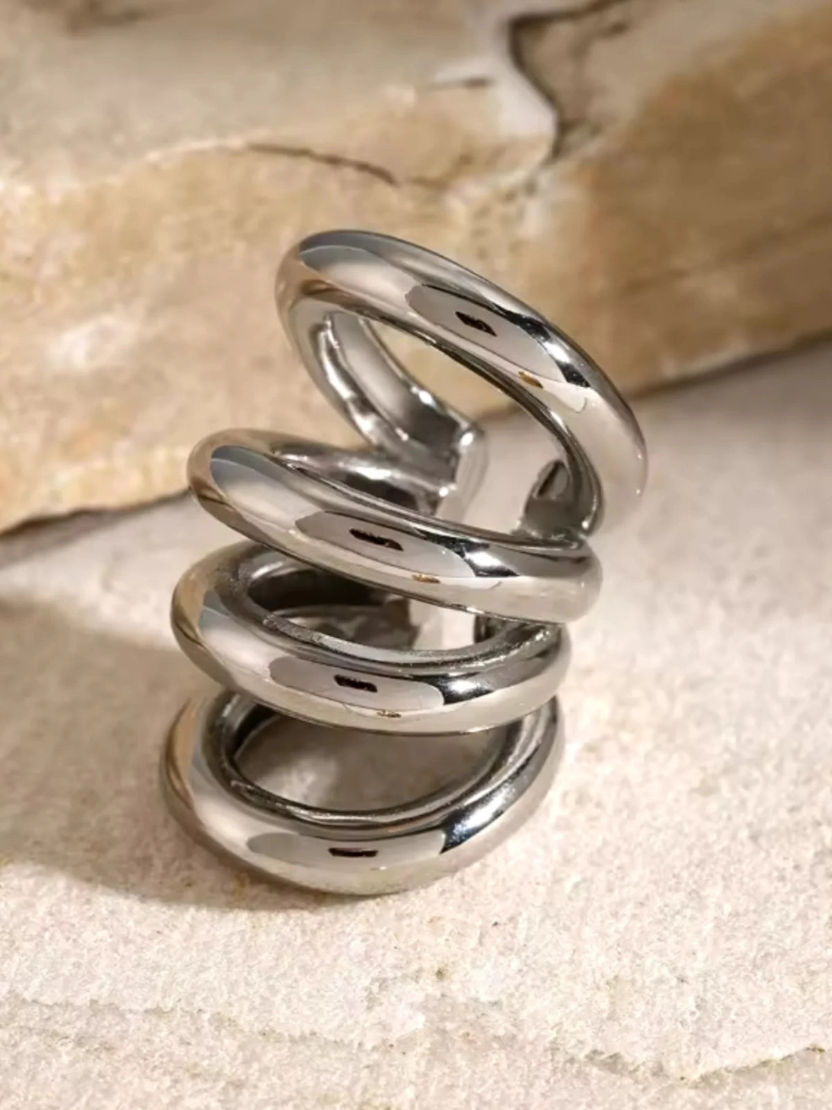 Faye Ear Cuff –Silver spiral design on a textured beige background