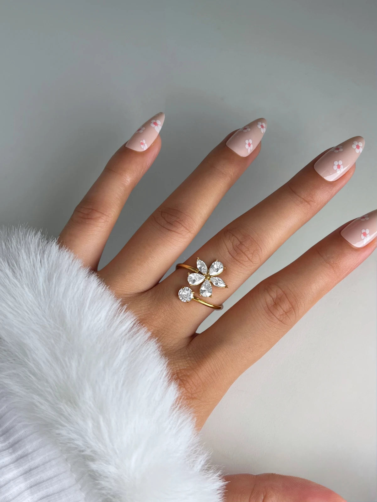 Flora Ring – Close-Up Detail-Hand wearing a decorative ring with a white background