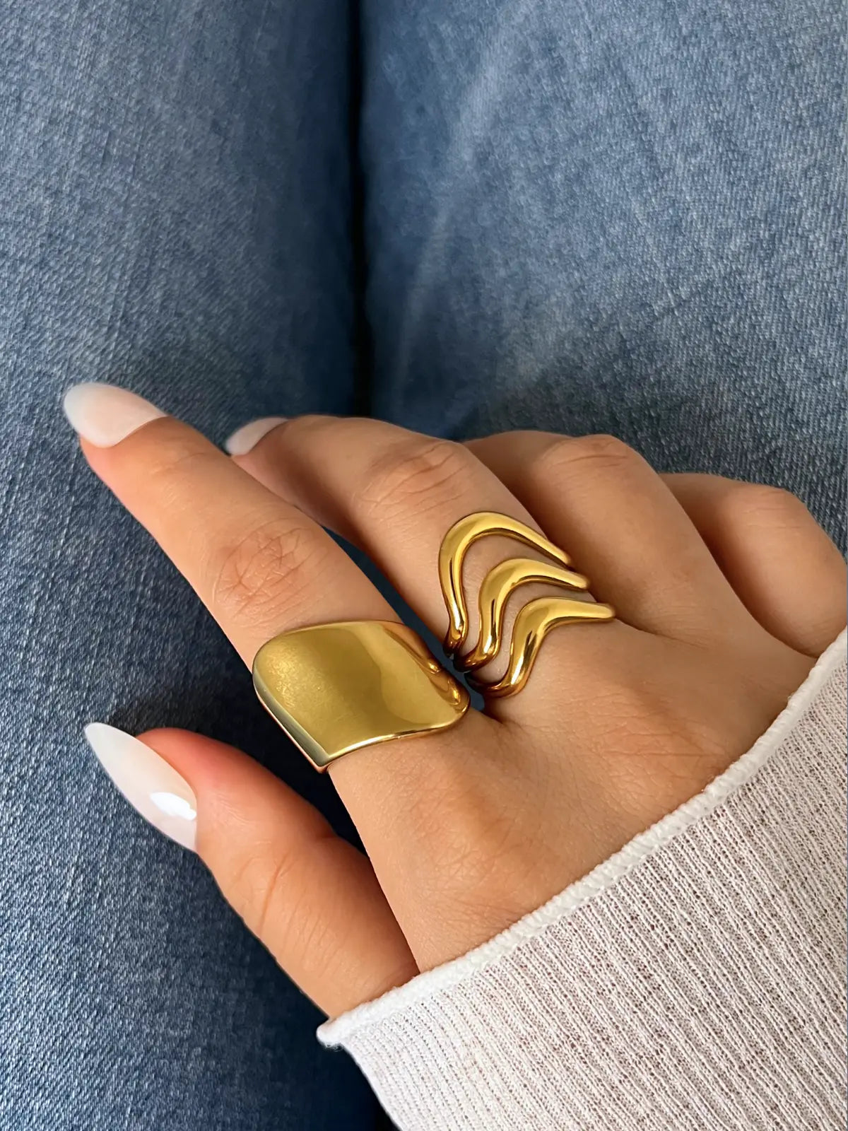 Golden Pulse Ring – Worn on Finger-Gold ring with a unique design worn on a finger against a denim background