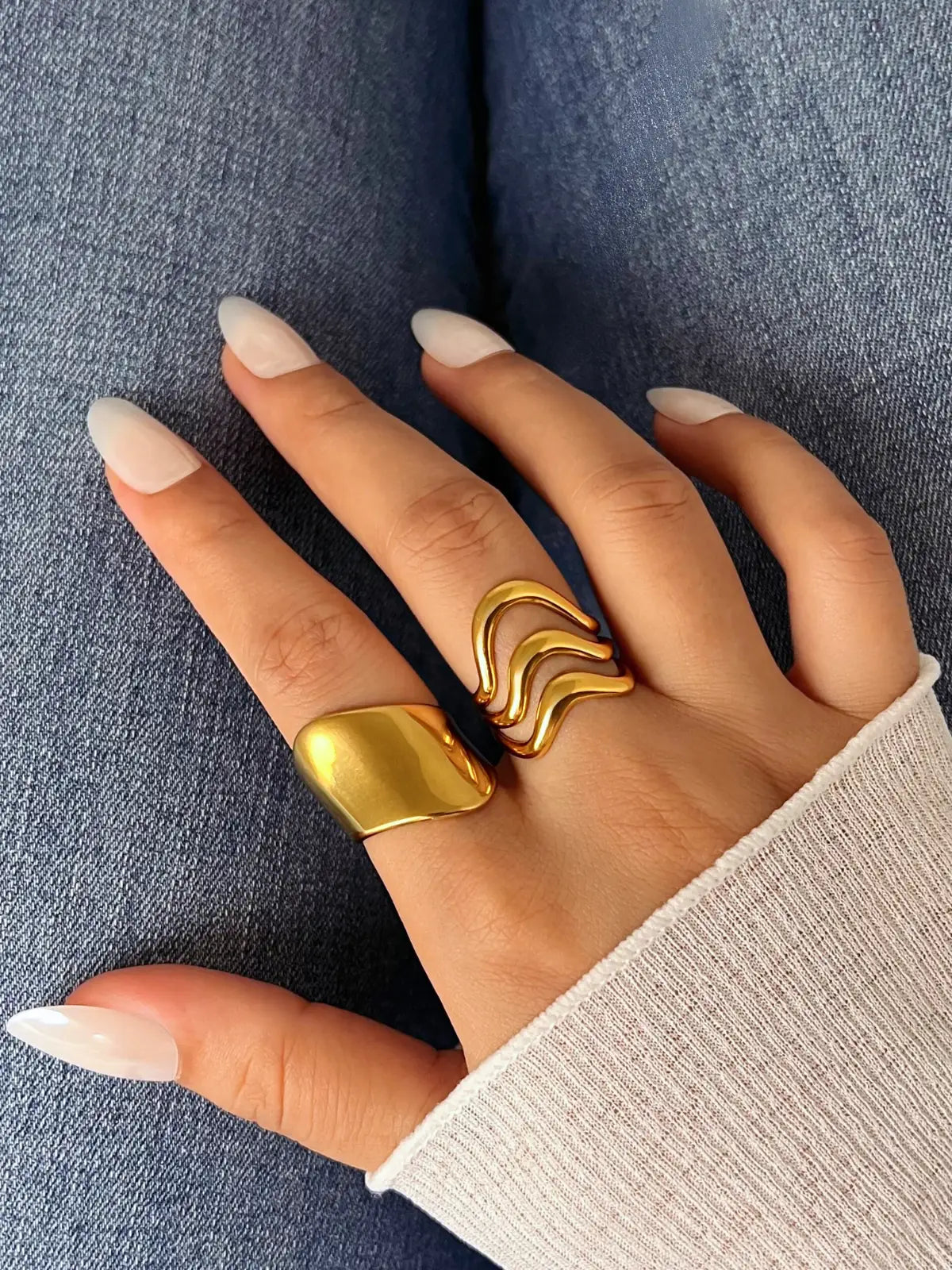 Golden Pulse Ring – Worn on Finger-Hand wearing two gold rings on a denim background