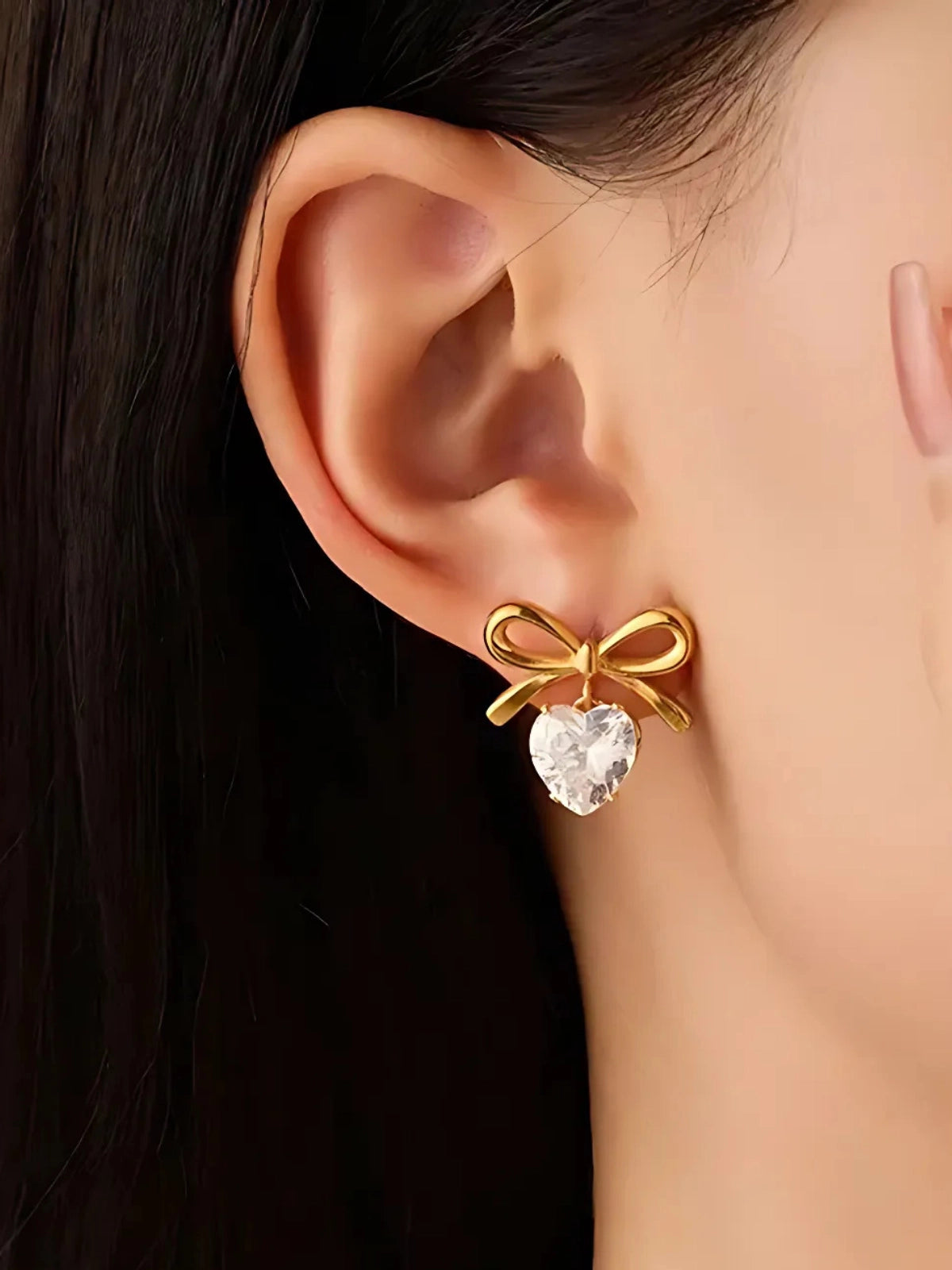 Heartbow Earring worn on ear — 18K gold‑plated stainless steel by Shine With Me, styled look showcasing the bow‑heart design.