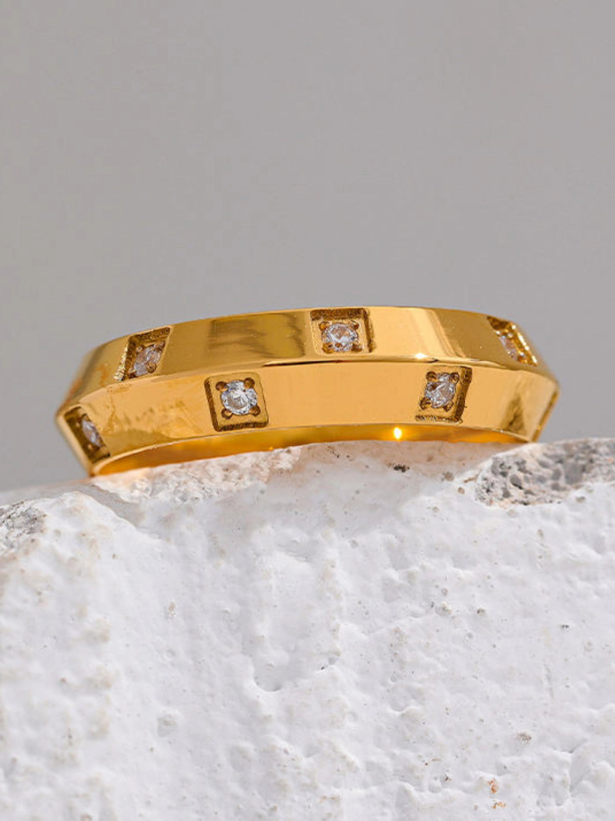 Lucena_Ring_Front_View Gold ring with diamond accents on a textured surface