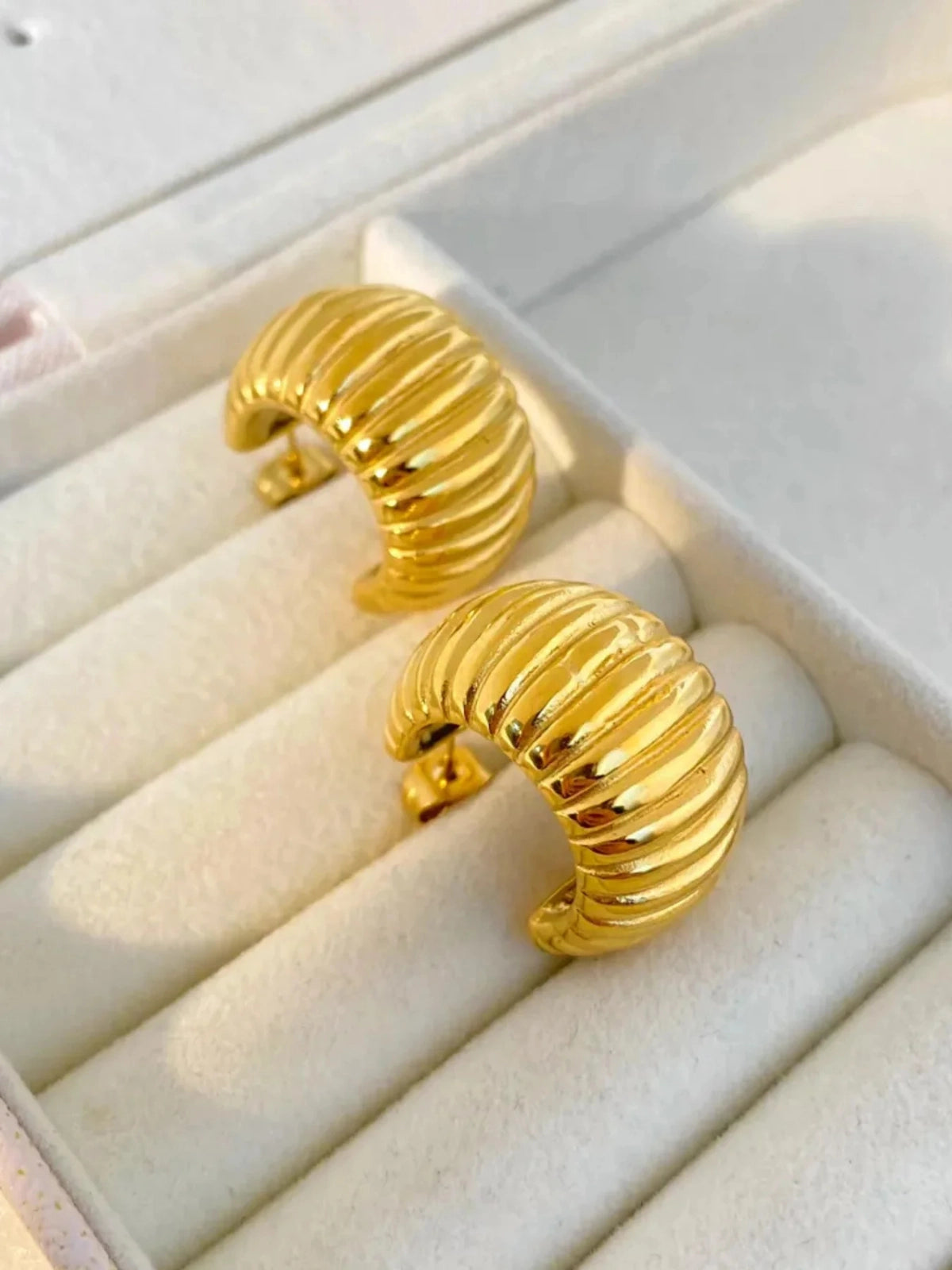 Marci Hoop Earring – Variant Gold earrings on a white jewelry display