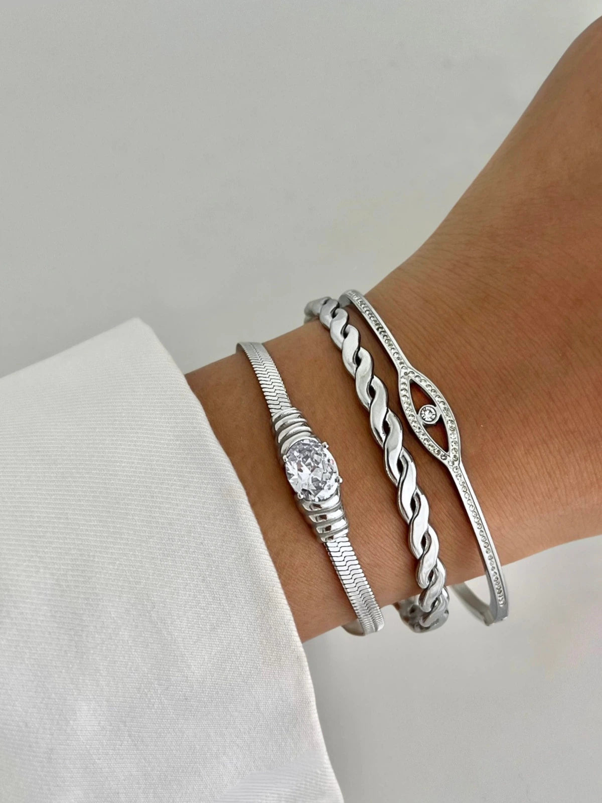 Natalie Bracelet worn on wrist — 18K stainless steel bracelet by Shine With Me, adjustable and elegant. Silver bracelets on a wrist against a neutral background