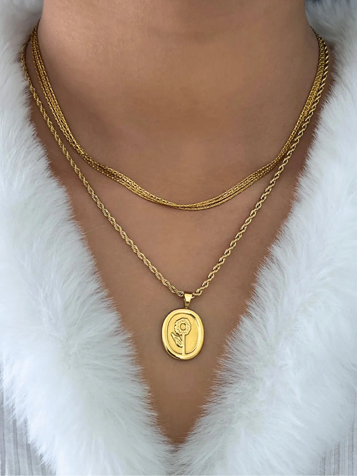 Sawana Necklace – On Model Styled Shot-Gold necklace with a pendant on a white fur background
