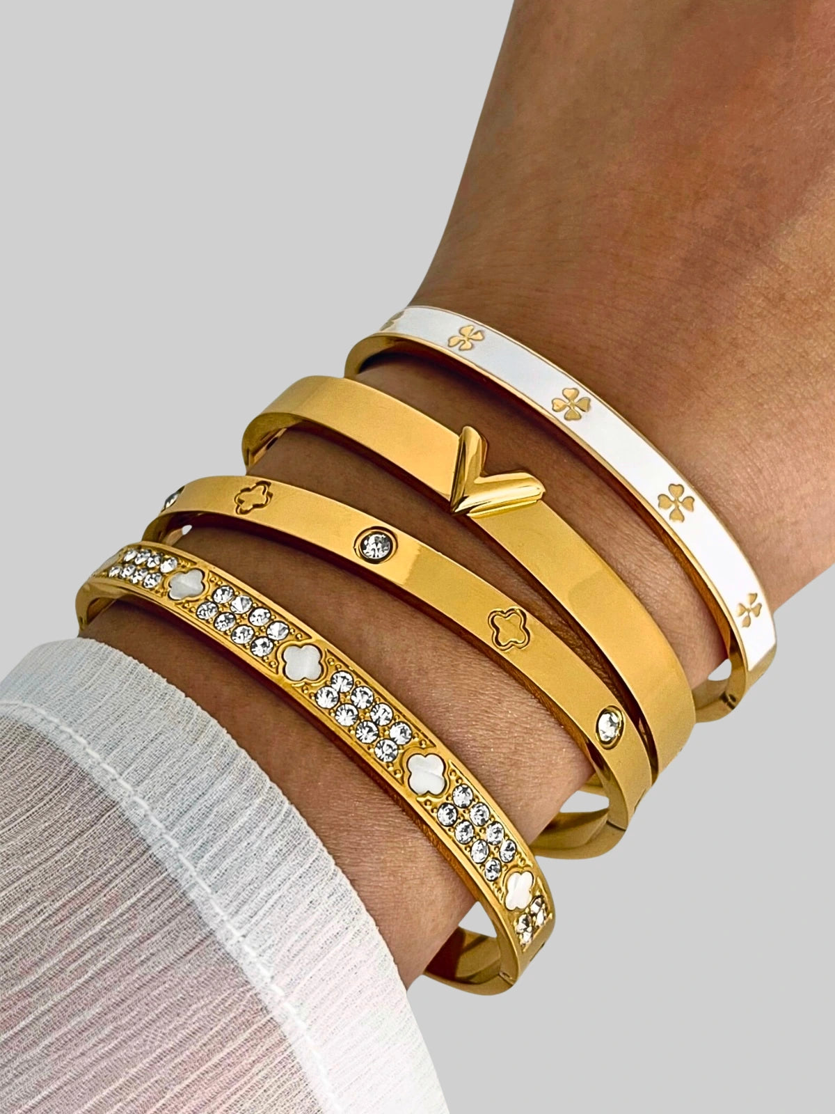 Sol Clover Bangle worn on wrist — gold-plated stainless steel bracelet by Shine With Me, clover design for refined everyday elegance.