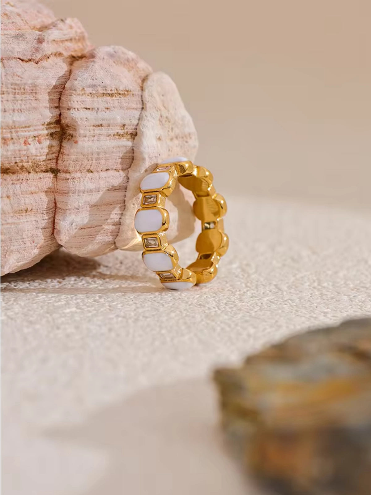 Zadia Ring | Shine With Me Gold ring with white stones on a sandy background