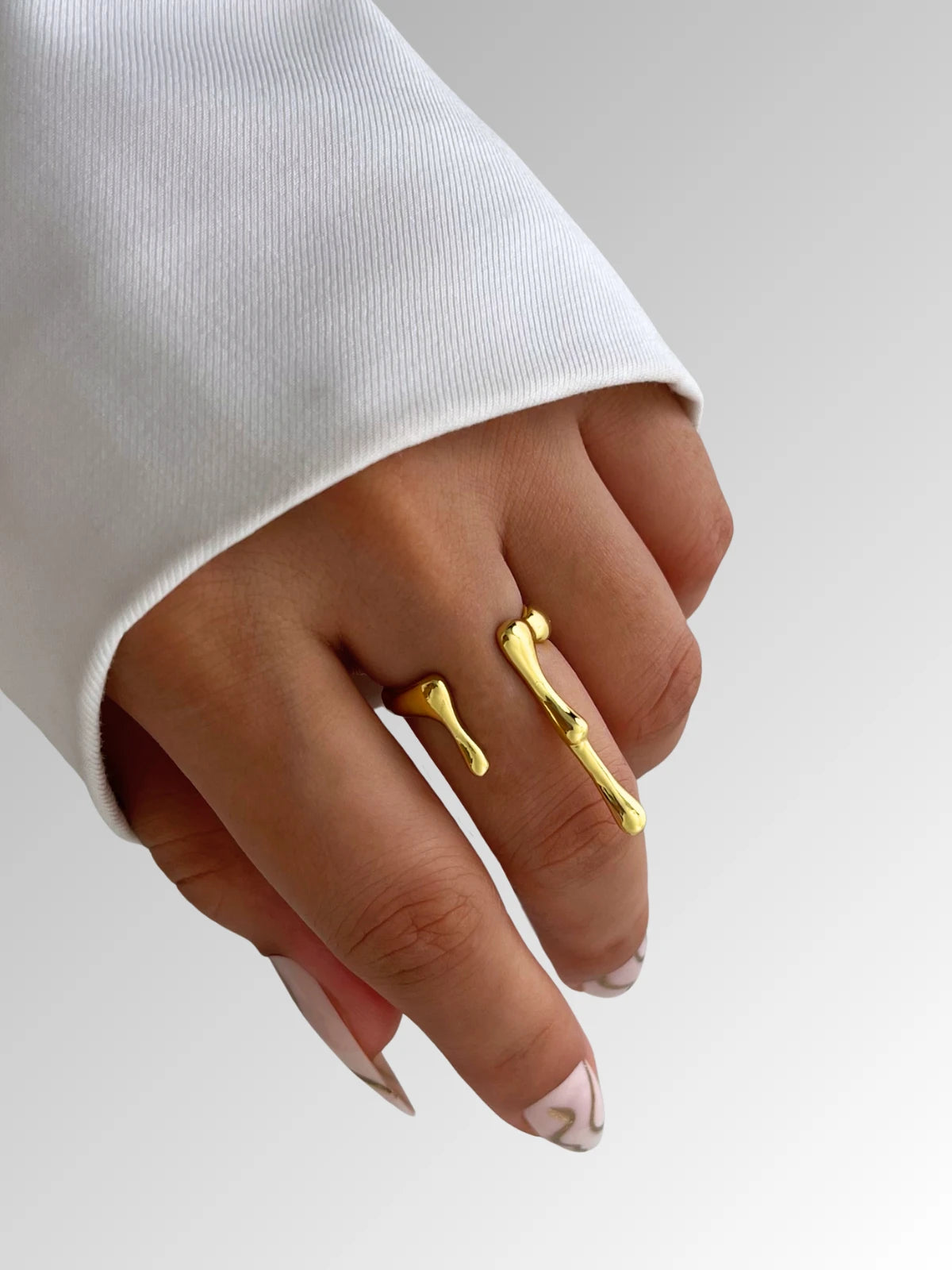 aqua-ring-side-angle-shine-with-me Gold ring on a finger with a white sleeve background