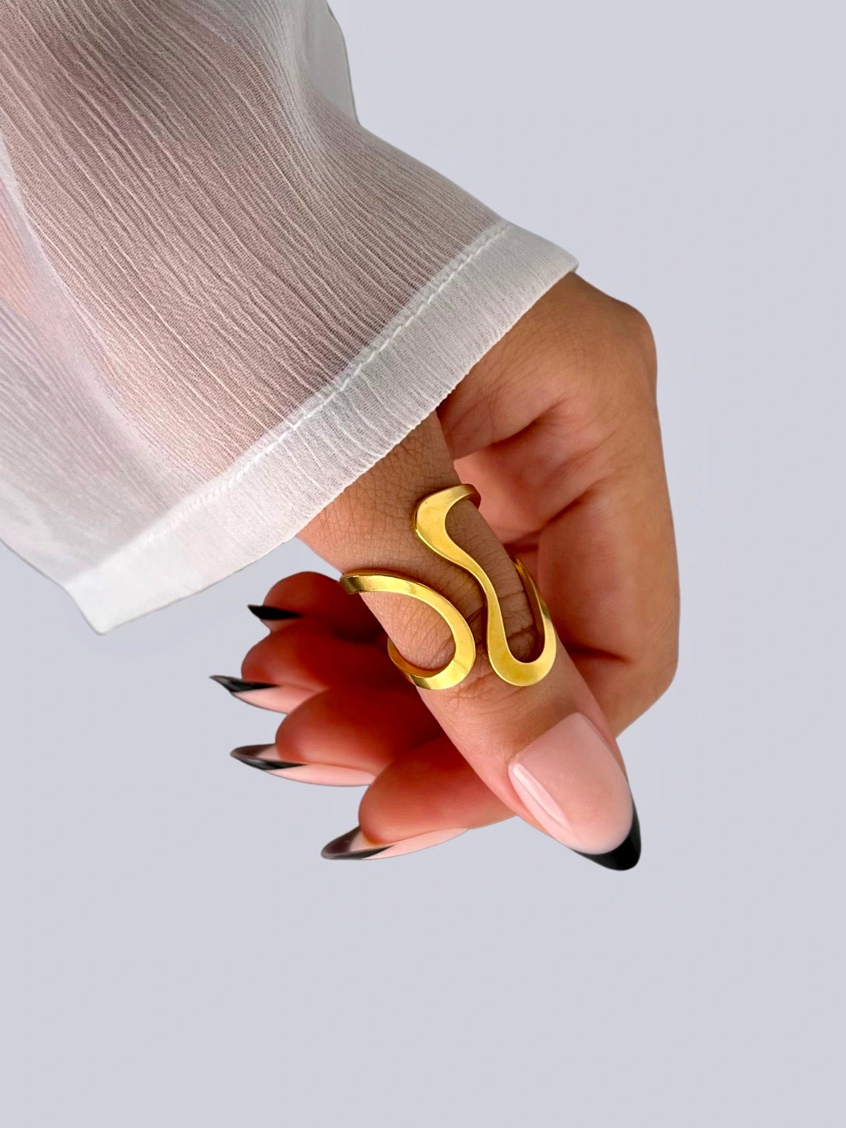 Aurelia Ring worn on hand — 18K gold-plated stainless steel open ring by Shine With Me, styled look, Gold ring on a hand with a white sleeve against a light gray background