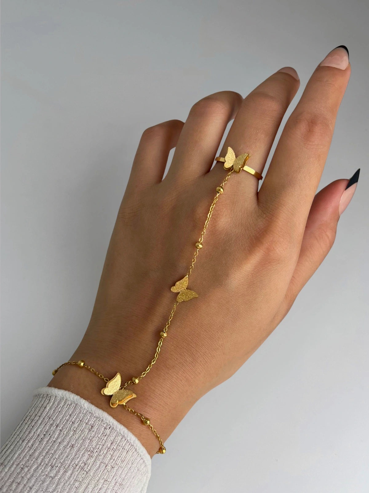 Butterfly Hand Lace worn on hand — gold-plated stainless steel hand harness by Shine With Me, butterfly design and everyday elegance