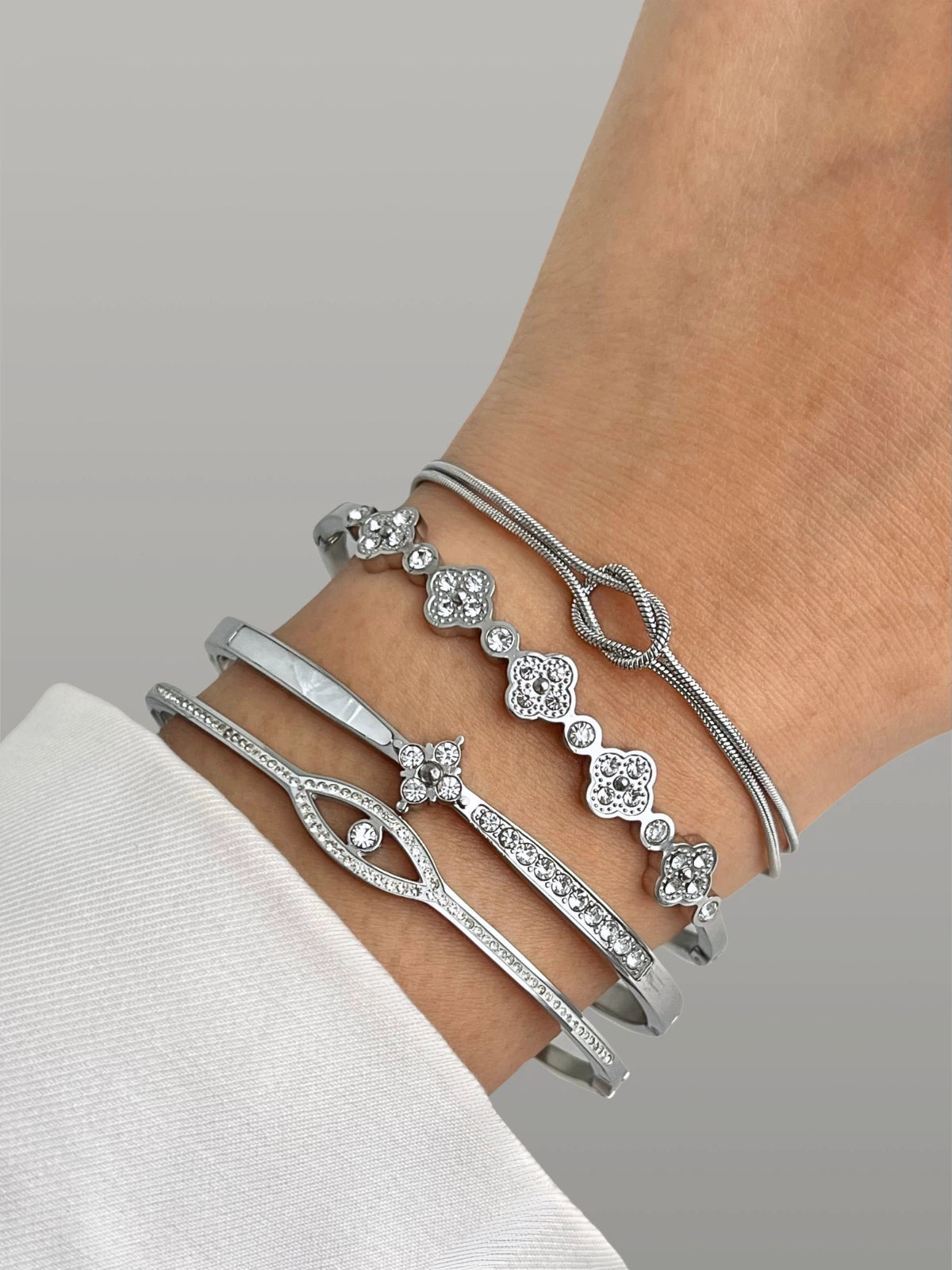 Clovelly Bangle – Styling Shot Silver bracelet with floral designs on a wrist against a neutral background