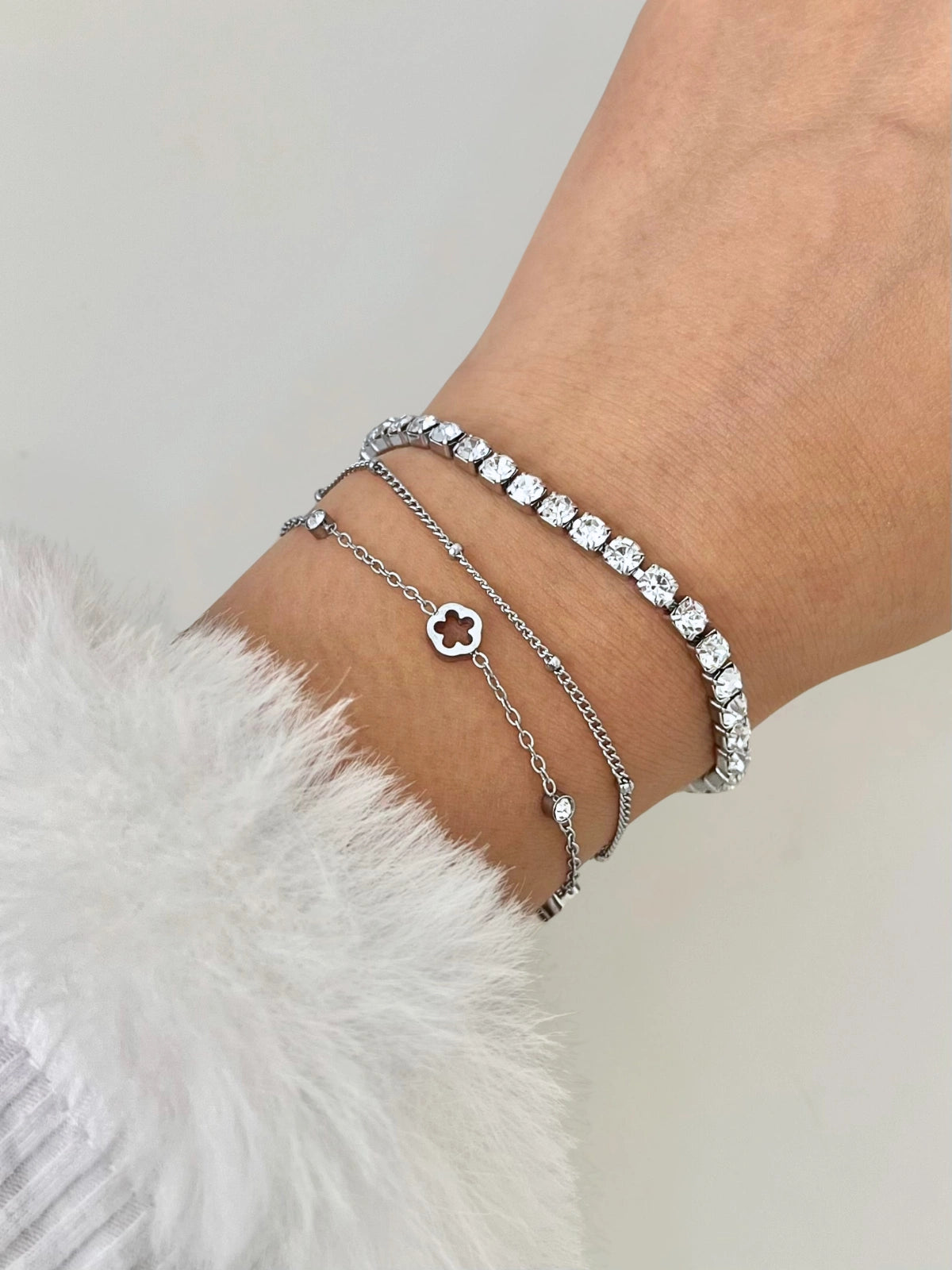 Cosmic Bracelet – On Wrist, Close-up of a wrist wearing multiple silver bracelets on a light background