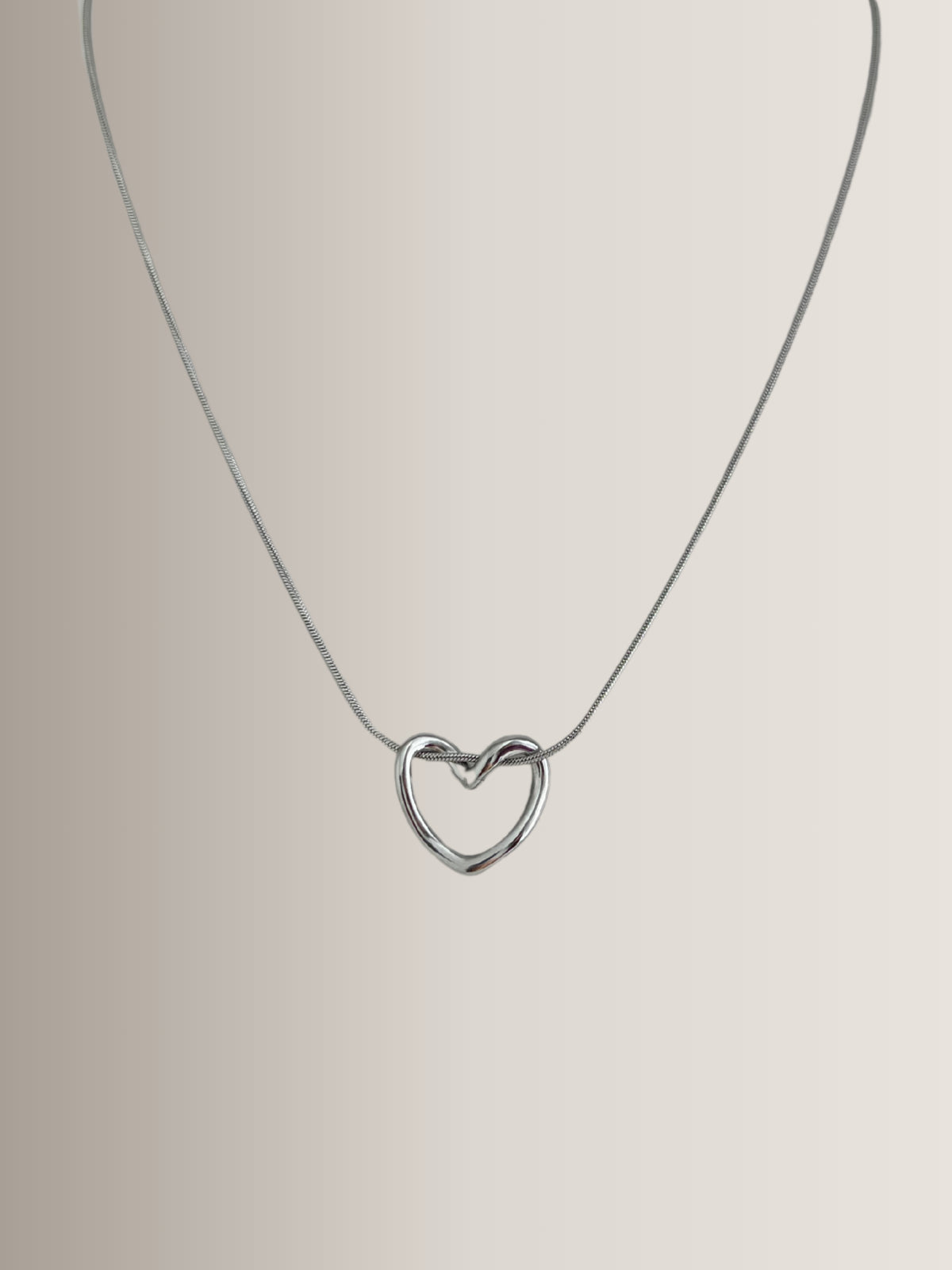 Darla Heart Necklace – Variant View-Silver heart-shaped pendant on a thin chain against a light gray background