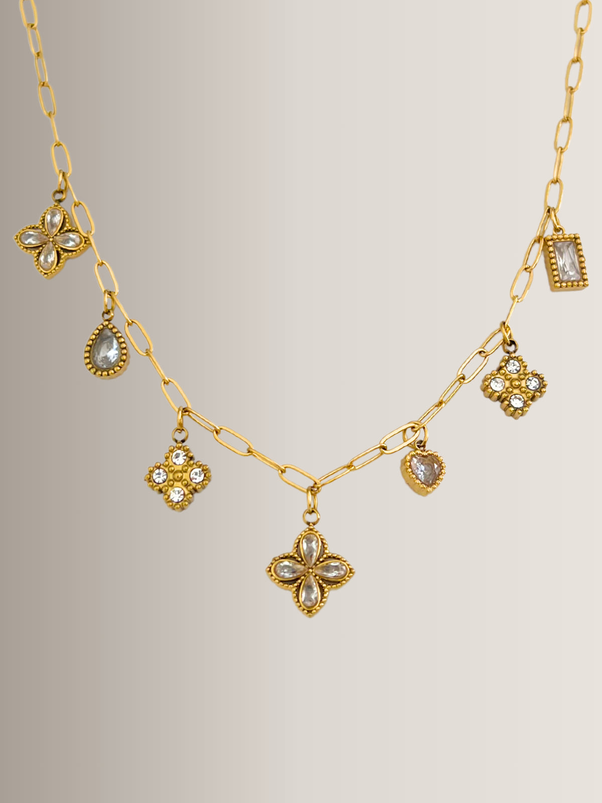 Close‑up of Delyra Clover Necklace by Shine With Me showing gold‑plated finish, stainless steel base and sparkling cubic zirconia clover motif.