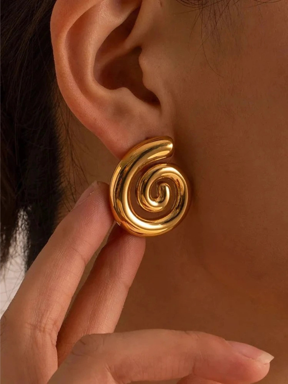 Dua Earring – On Ear Styled Shot-Gold spiral earring worn on an ear with a blurred background