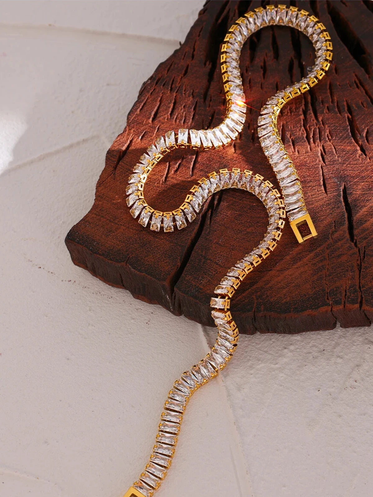 Elly_Chain Gold and crystal bracelet on a wooden surface