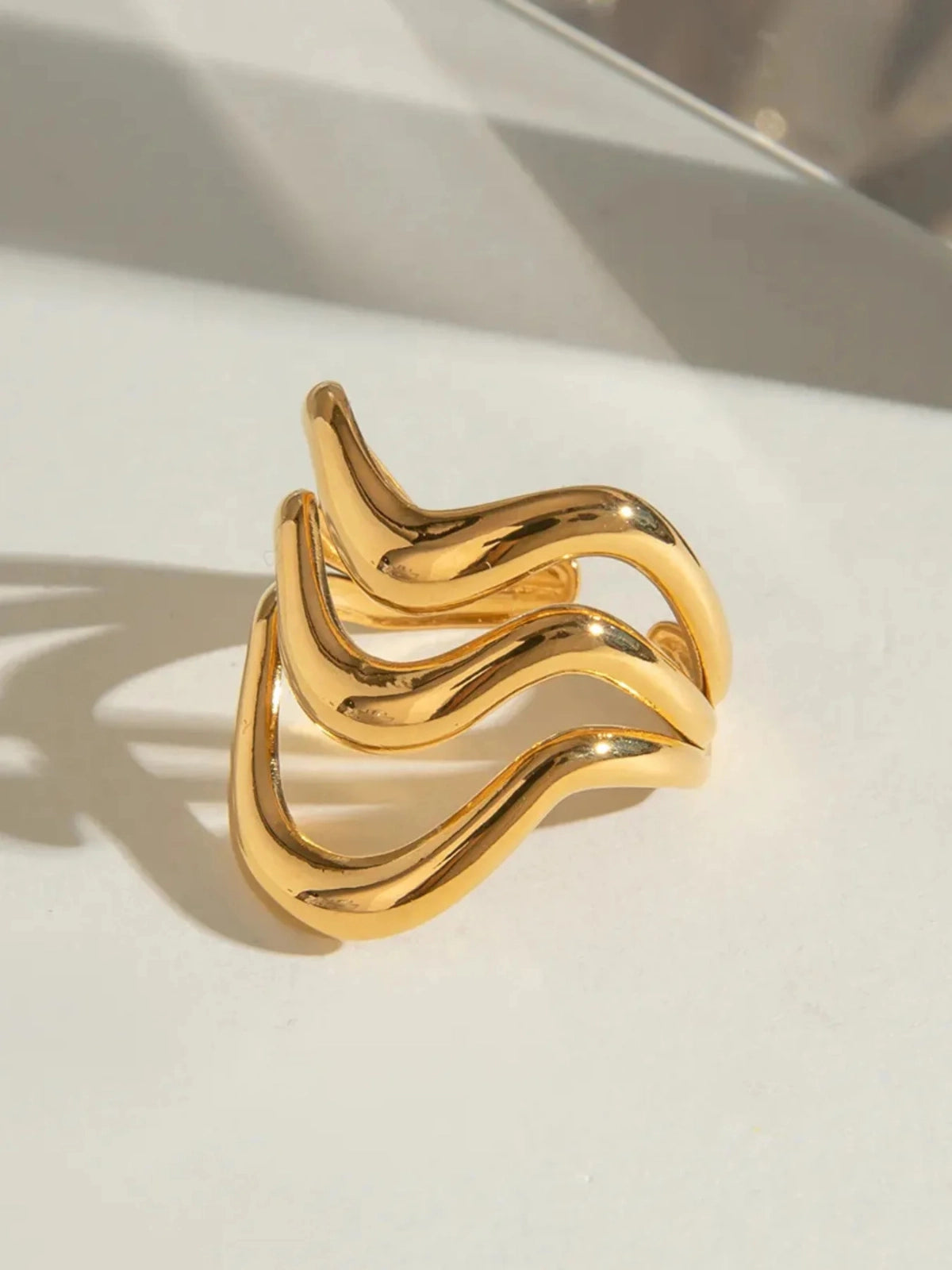Estela Ring – Detail-Gold ring with wavy design on a light background