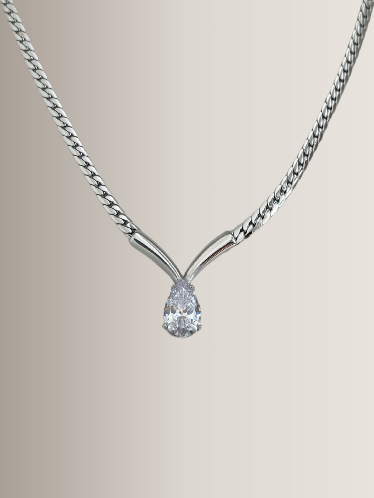 Imber Necklace – Close‑Up Detail-Silver necklace with a teardrop-shaped diamond pendant on a neutral background