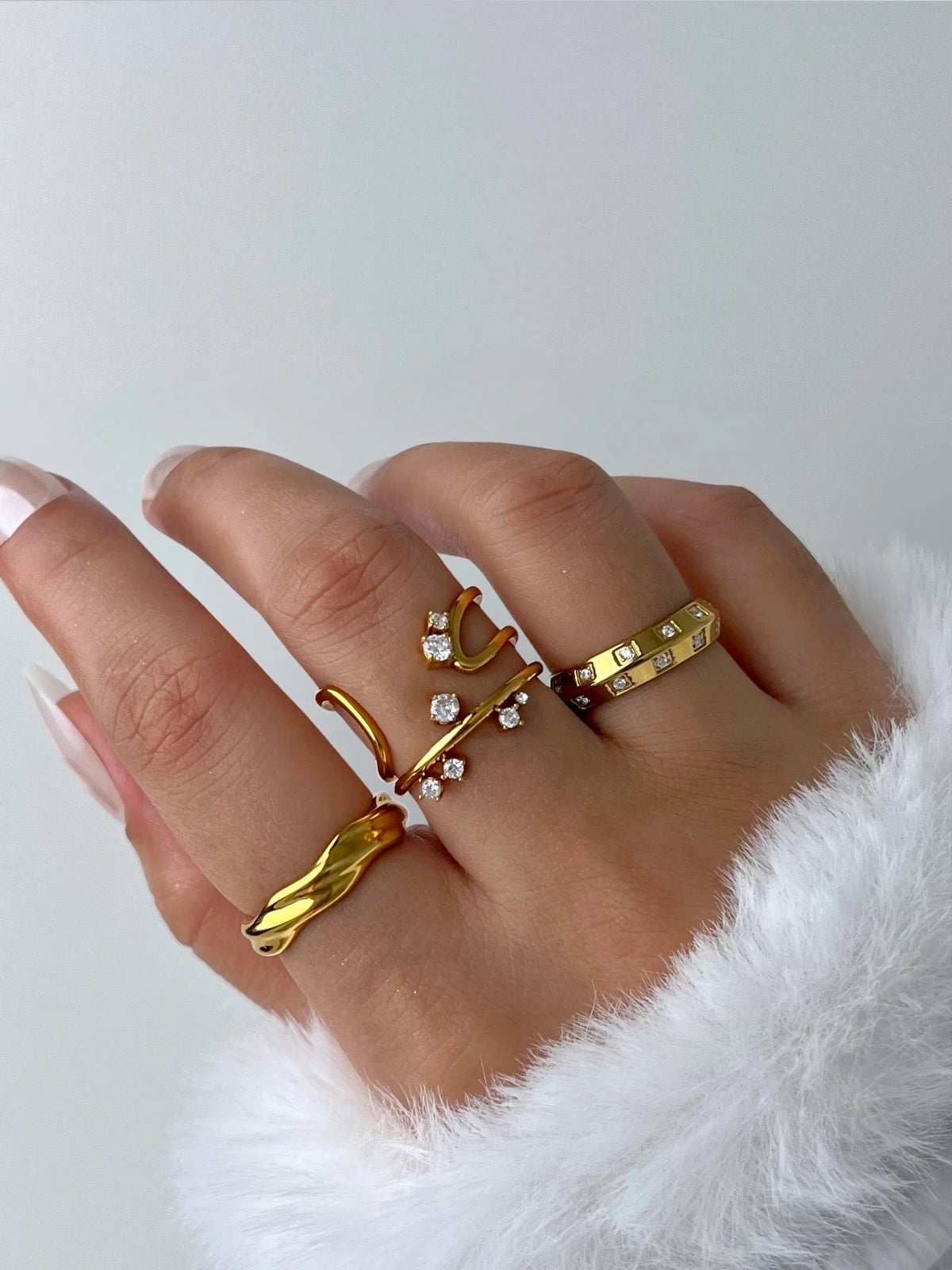 Lucena Ring – Lifestyle / Everyday Look-Hand wearing multiple gold rings on a white background