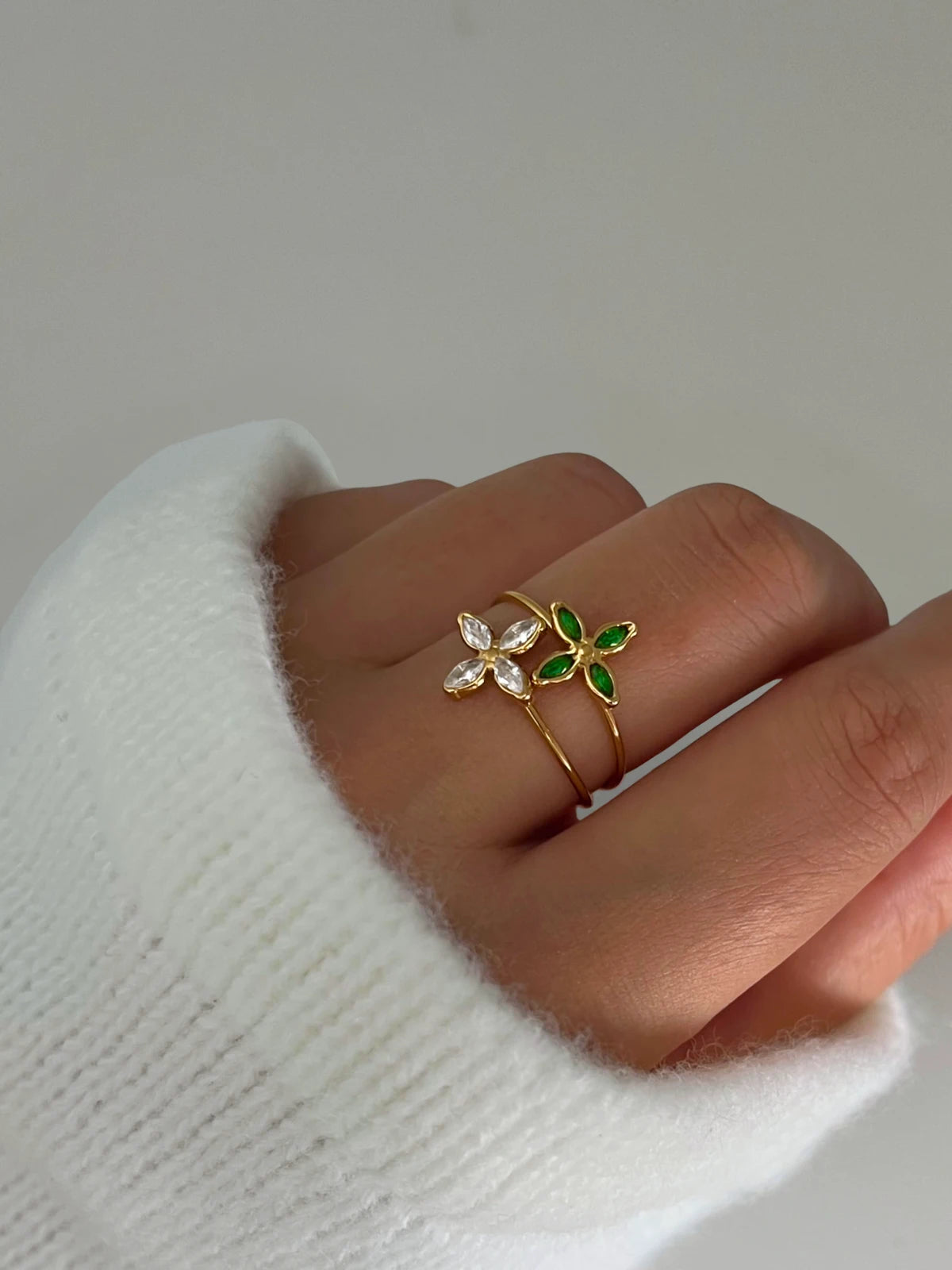 Lucia Ring-Hand wearing two rings with floral designs on a white background