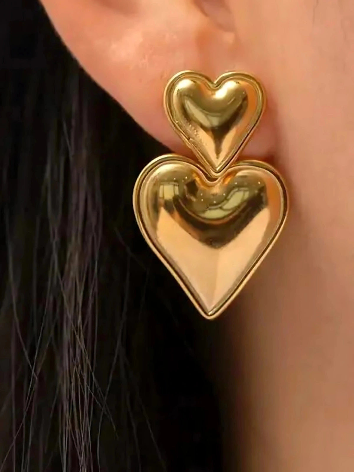 Lunara Double Heart Earring worn on ear — 18K gold‑plated stainless steel by Shine With Me, styled for everyday elegance.
