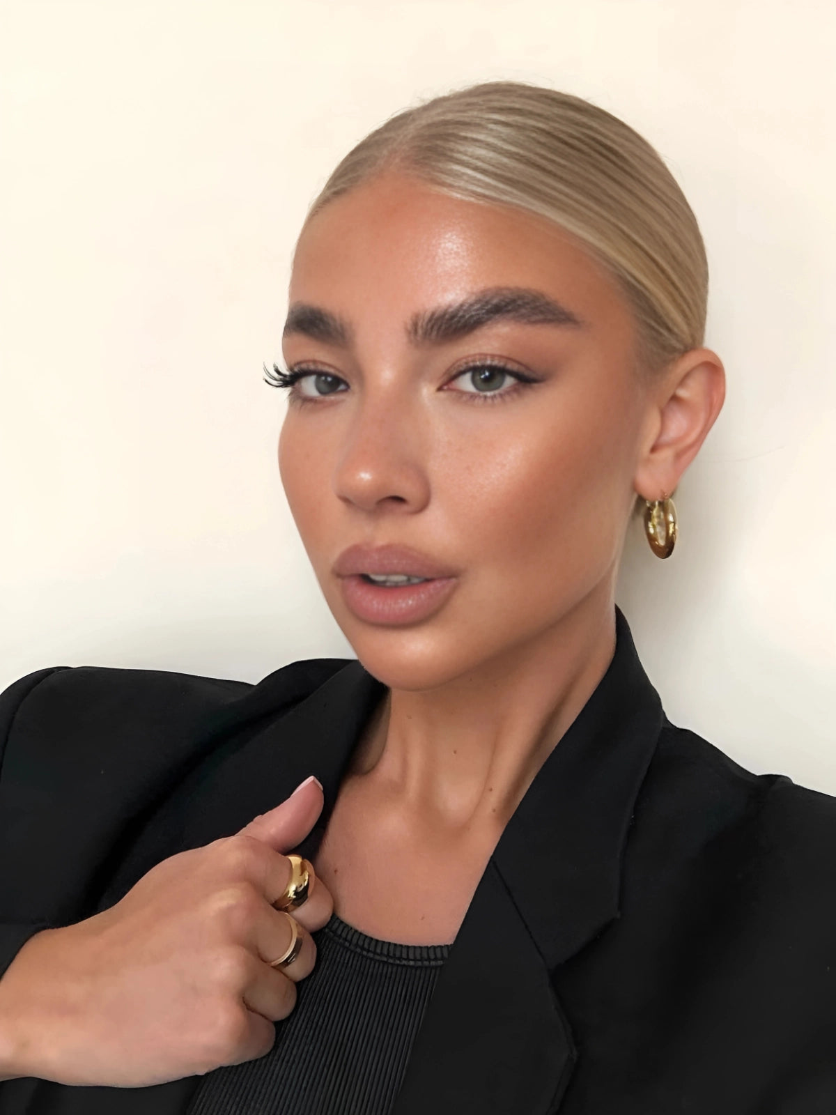 Luxe Earring – On Ear Styled Shot-Woman with styled hair and makeup wearing a black outfit against a plain background