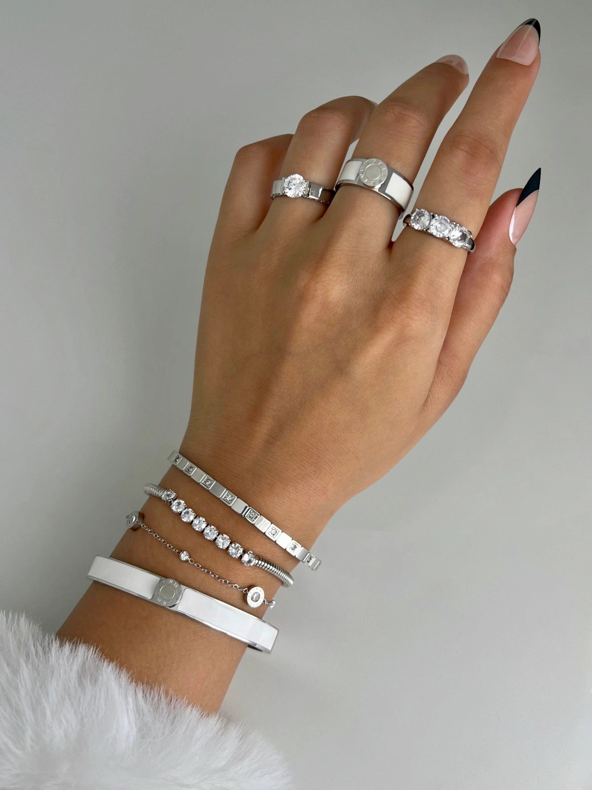 Miranda Bangle worn on wrist — 18K gold-plated stainless steel bangle (65 mm width) by Shine With Me, styled look, Hand wearing multiple silver rings and bracelets on a neutral background