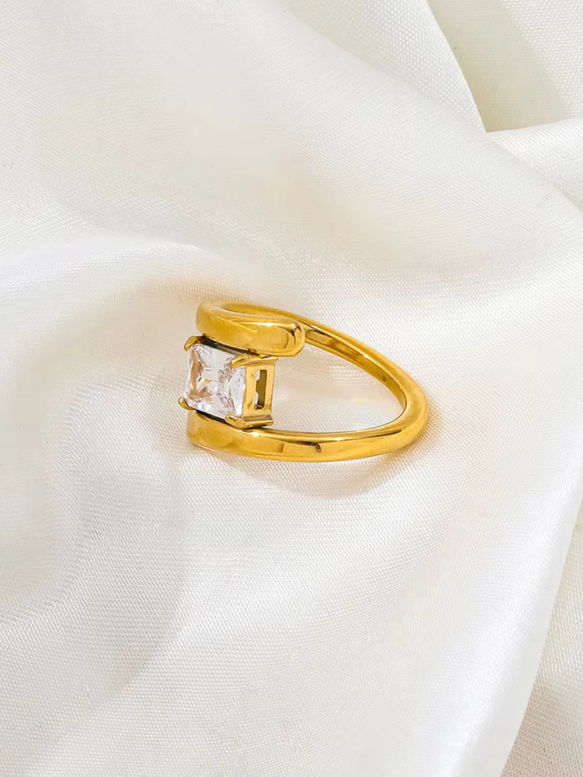 Moonbeam_Ring_Front_View_1Gold ring with a diamond on a white fabric background