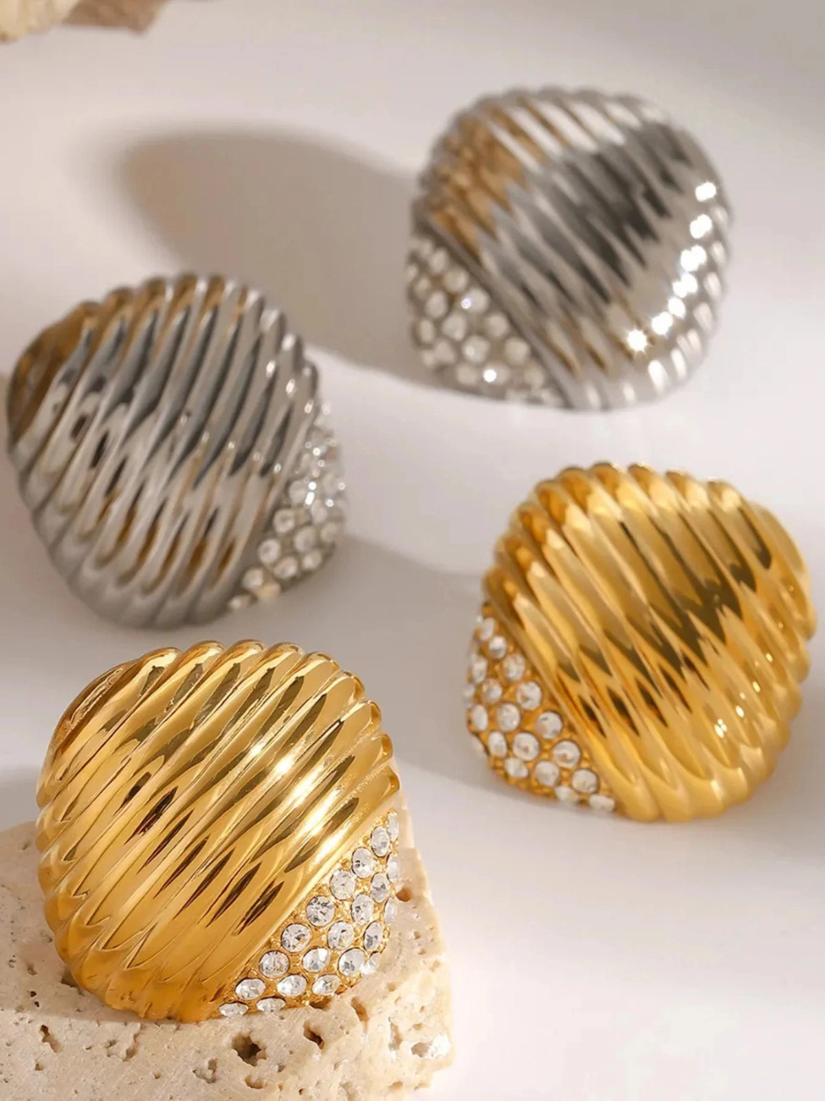 Natasha Earring – Close‑Up Detail-Gold and silver textured jewelry pieces on a light background