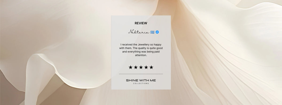 A review card for Shine With Me Jewelry by Nektaria, displayed against a soft, draped beige background. The card is white with black text and a blue brand logo, featuring a five-star rating.