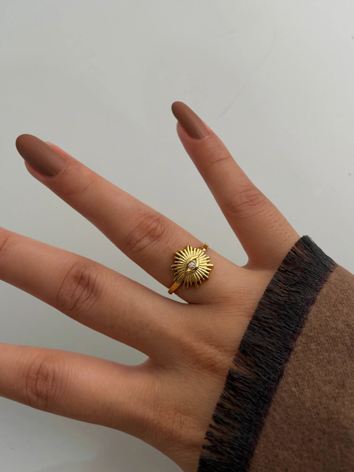 Rawah Necklace & RING-Gold ring on a finger against a plain background