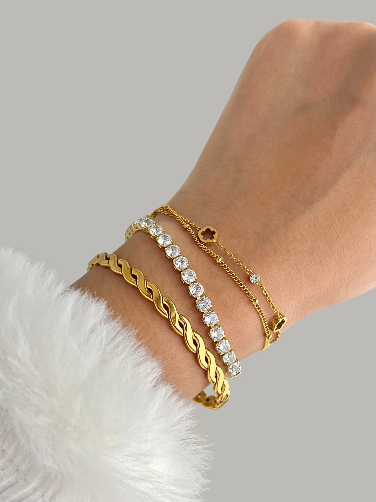 Riva Flower Bracelet – Gold Variants, Gold and diamond bracelet on a wrist with a neutral background