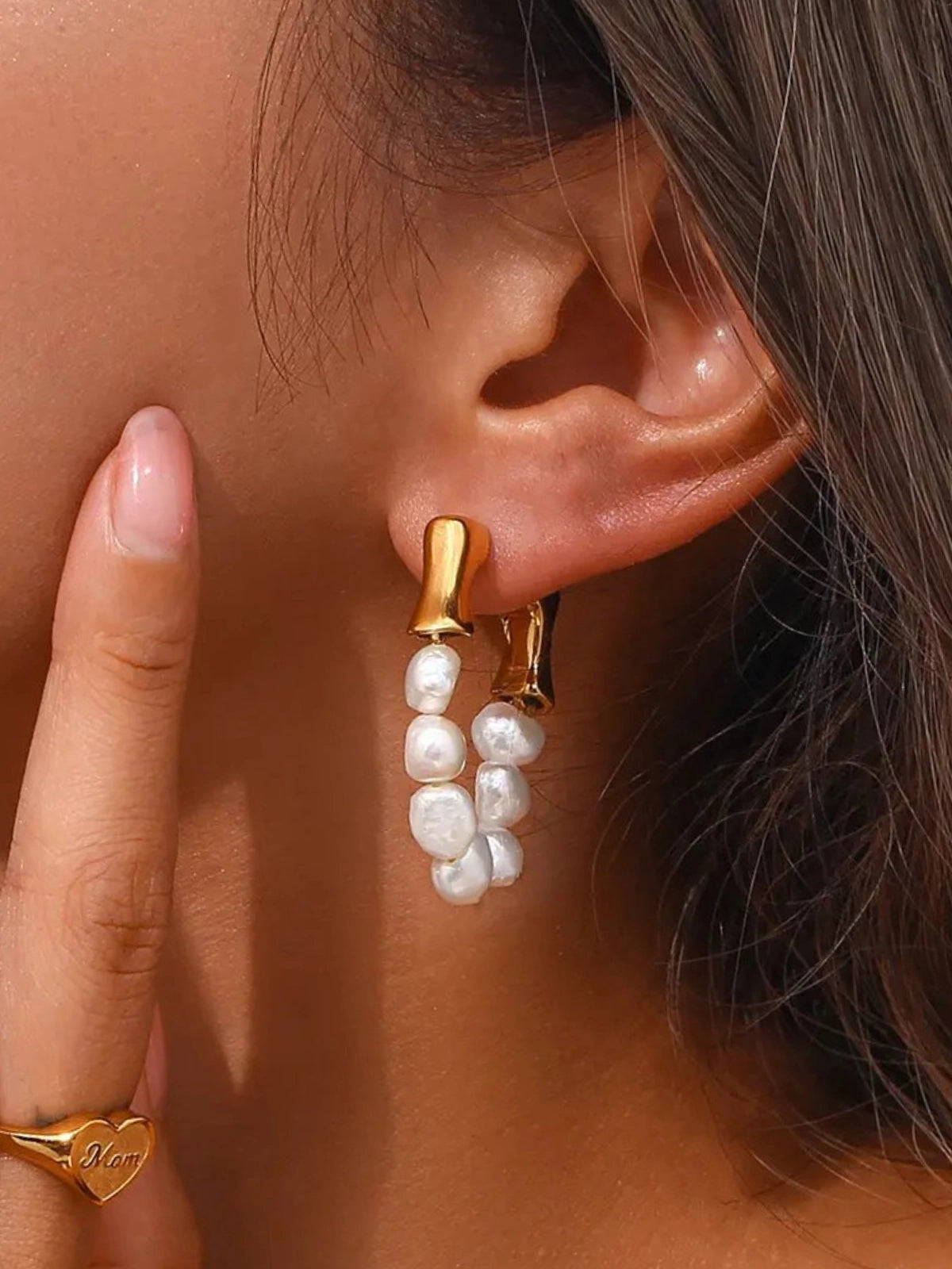 Seafoam Pearl Earrings – On Ear Styled Shot-Close-up of an ear wearing a gold earring with pearl-like beads, blurred background