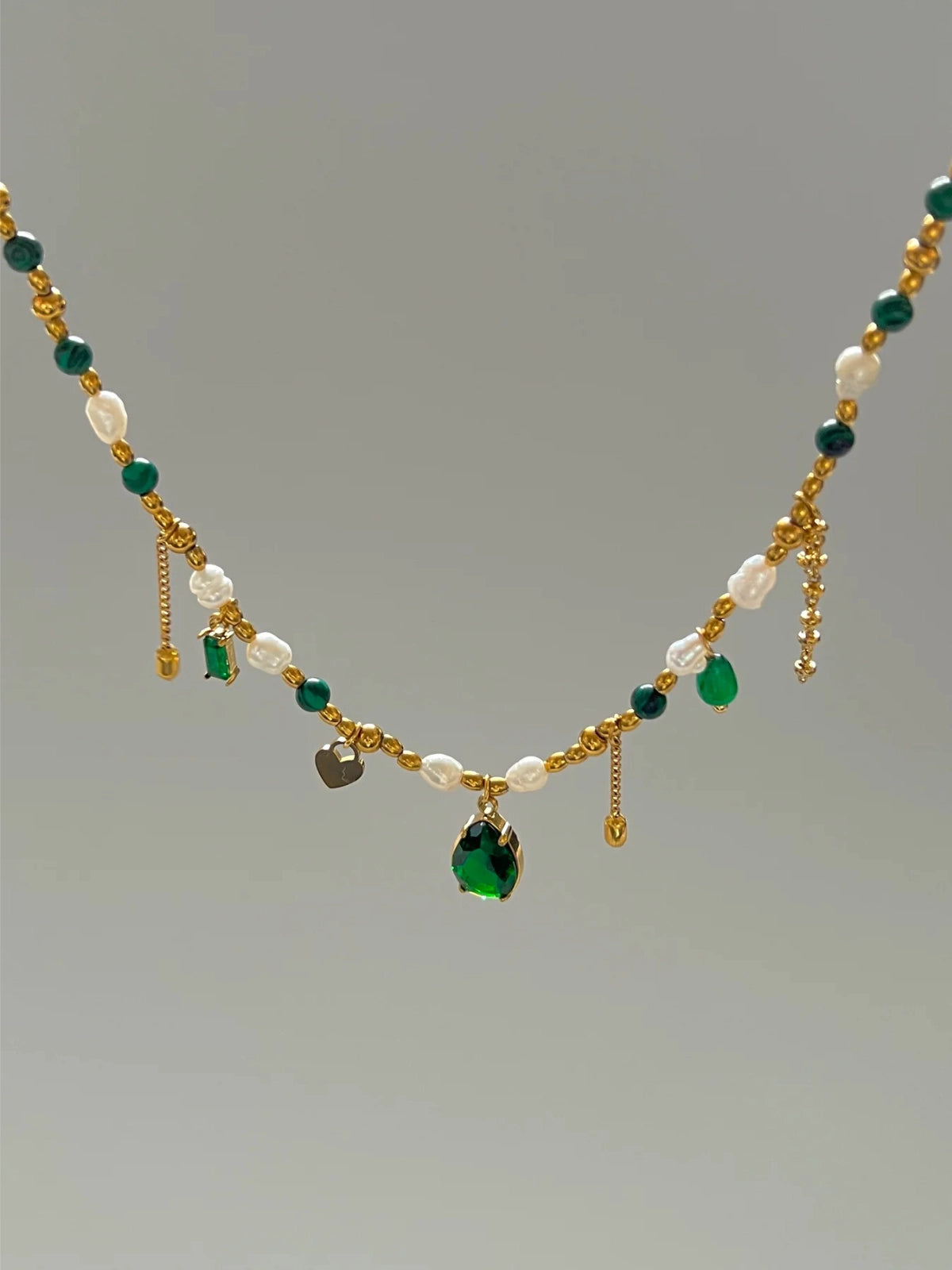 Shine With Necklace – Close‑Up Detail -Necklace with green and white beads on a gray background