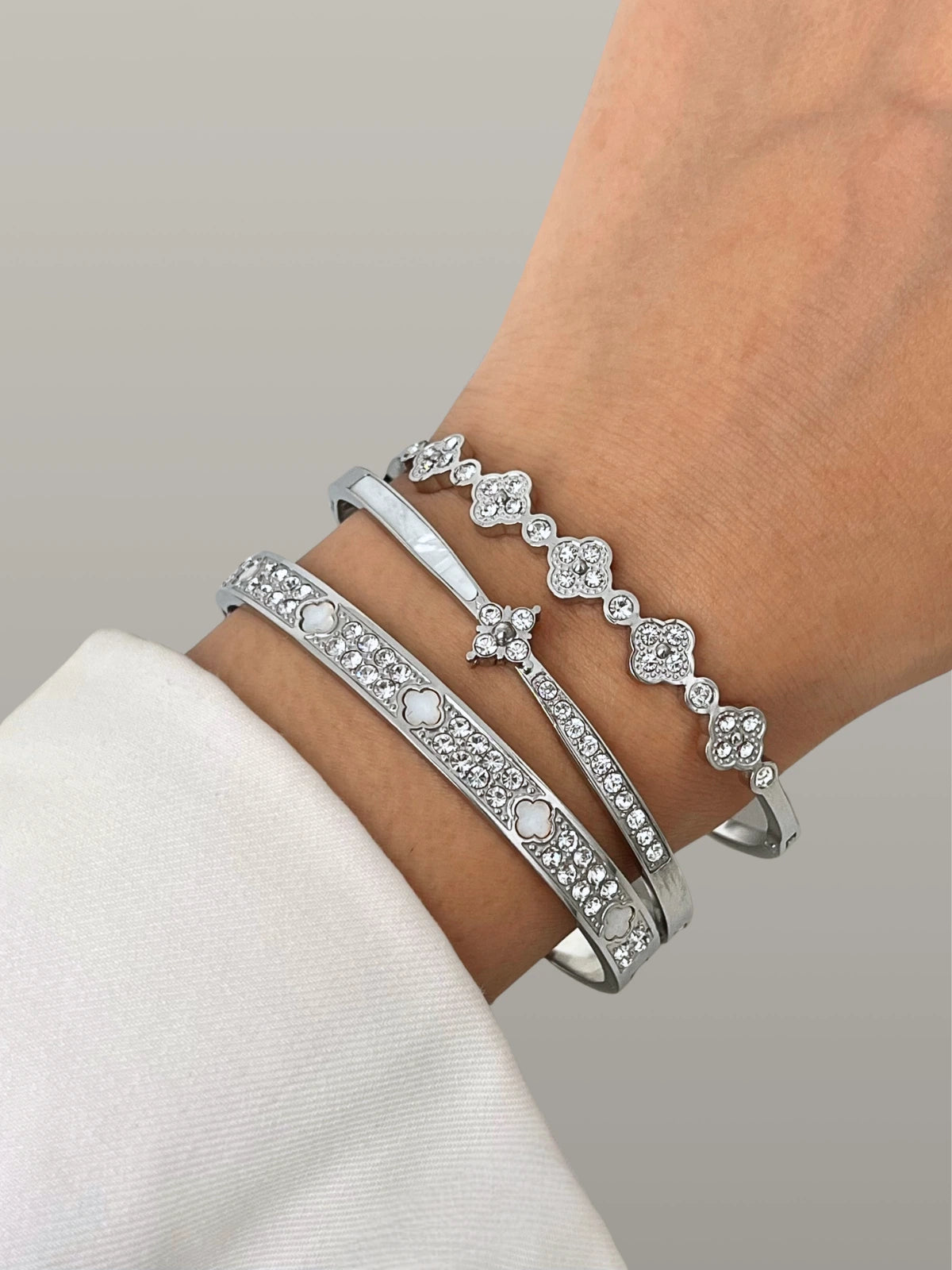Sol Clover Bangle Silver with floral design on a wrist against a neutral background