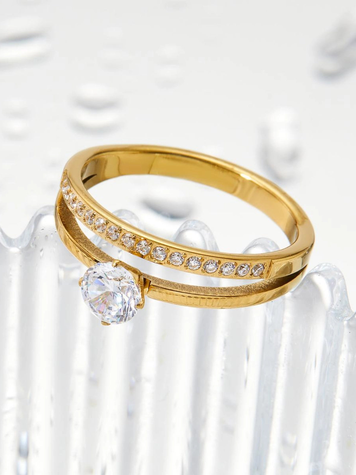 Sophisticate_Ring_Front_View_1. Gold ring with a large diamond and smaller diamonds on a white background