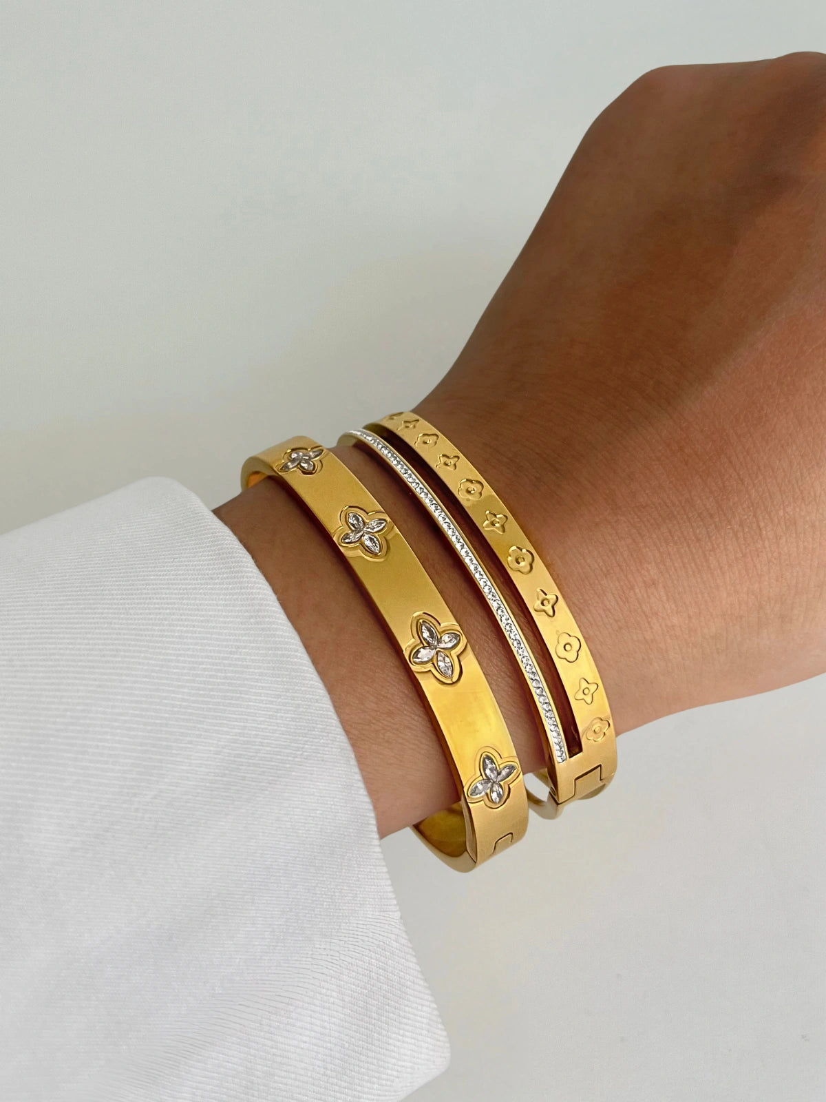Victoria Clover Bangle worn on wrist — Shine With Me gold-plated stainless steel bracelet, bold clover design for modern elegance.