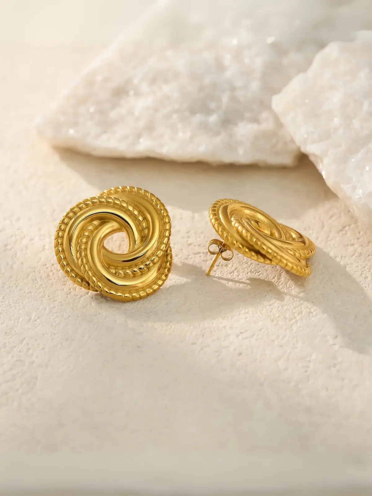 Vintage Earrings Gold  on a textured beige surface