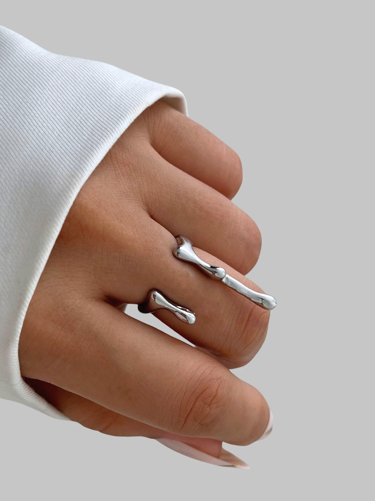 aqua-ring-lifestyle-shot-shine-with-me Silver branch-shaped ring on a finger against a neutral background