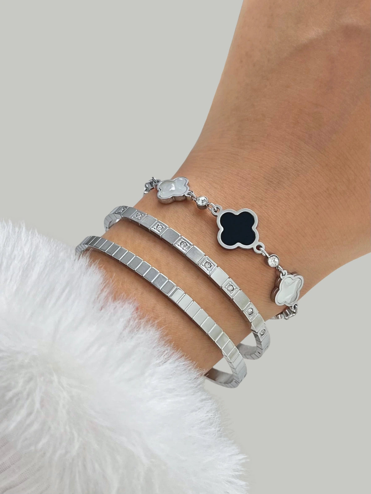 Selina Bangle Silver with clover charm on wrist against a neutral background